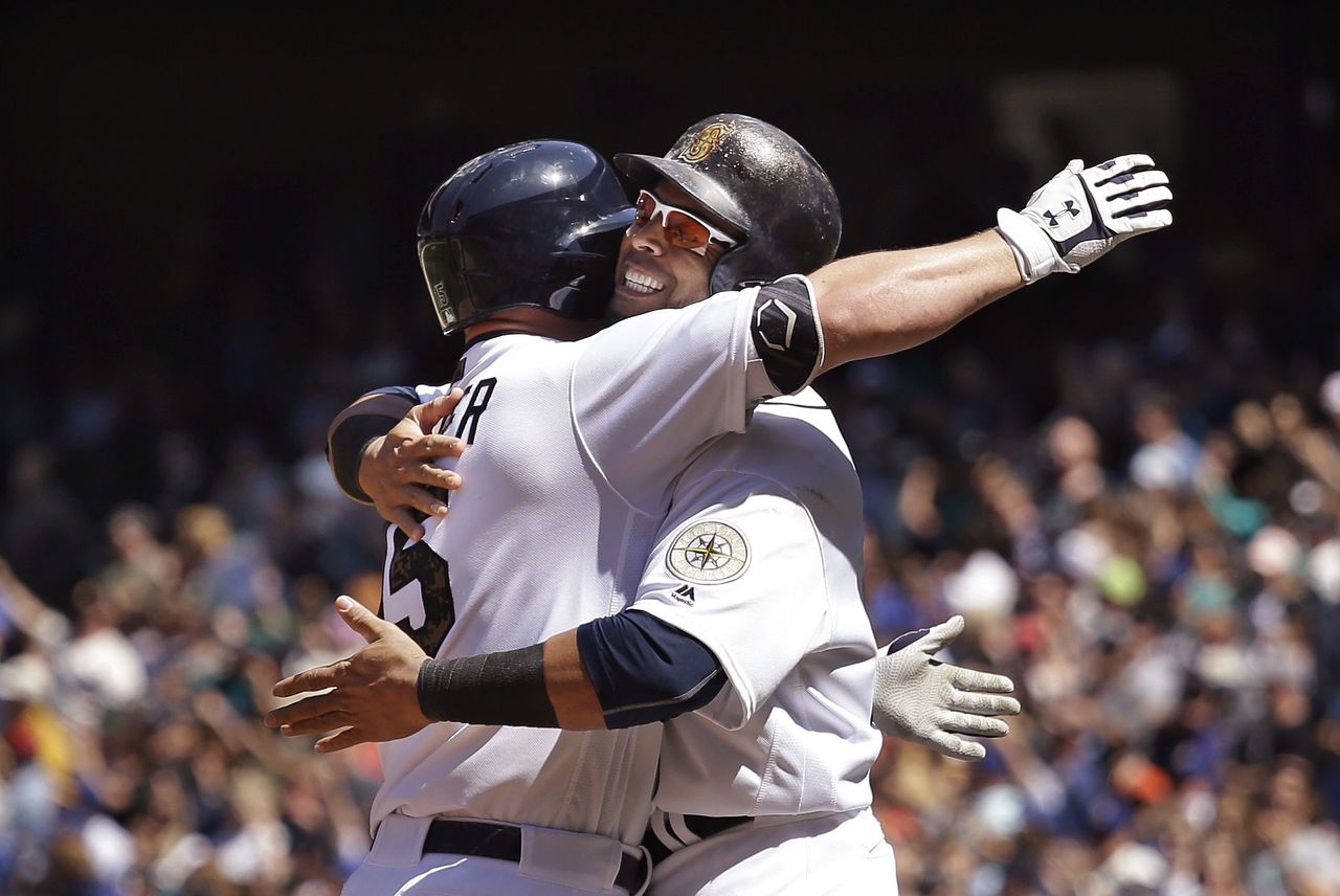 The Mariners’ Kyle Seager (left) is greeted at home plate by Nelson Cruz after Seager hit a two-run home run in the sixth inning of Monday’s game against the Padres.