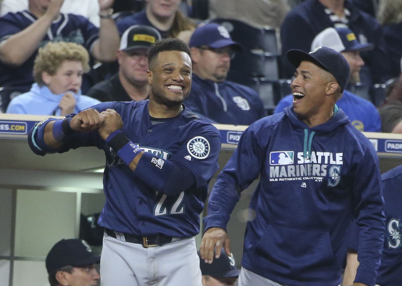 The Mariners’ Robinson Cano (left) and Leonys Martin celebrate during Seattle’s nine-run seventh inning Thursday against the Padres in San Diego.