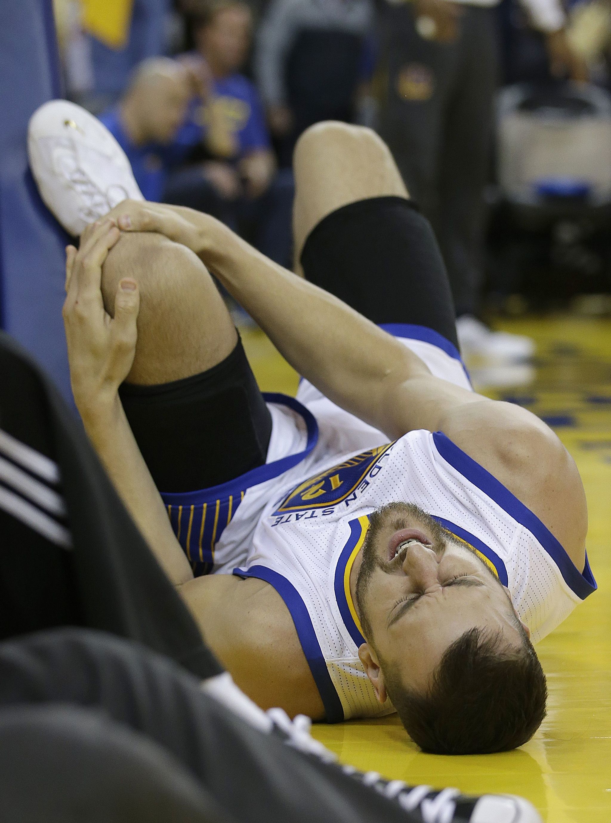 Golden State Warriors center Andrew Bogut grabs his leg during the second half of Game 5 of the NBA Finals. The Warriors announced Monday that Bogut will miss the rest of the series.