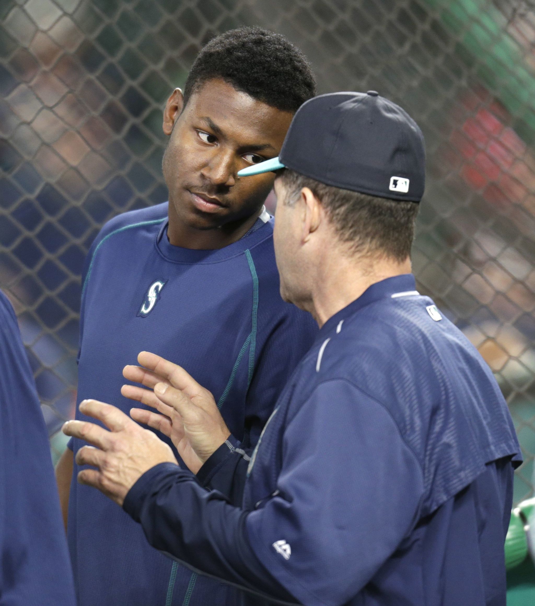 Mariners first-round draft pick Kyle Lewis talks with Seattle batting coach Edgar Martinez during batting practice before the team’s baseball game against the Texas Rangers on Saturday.