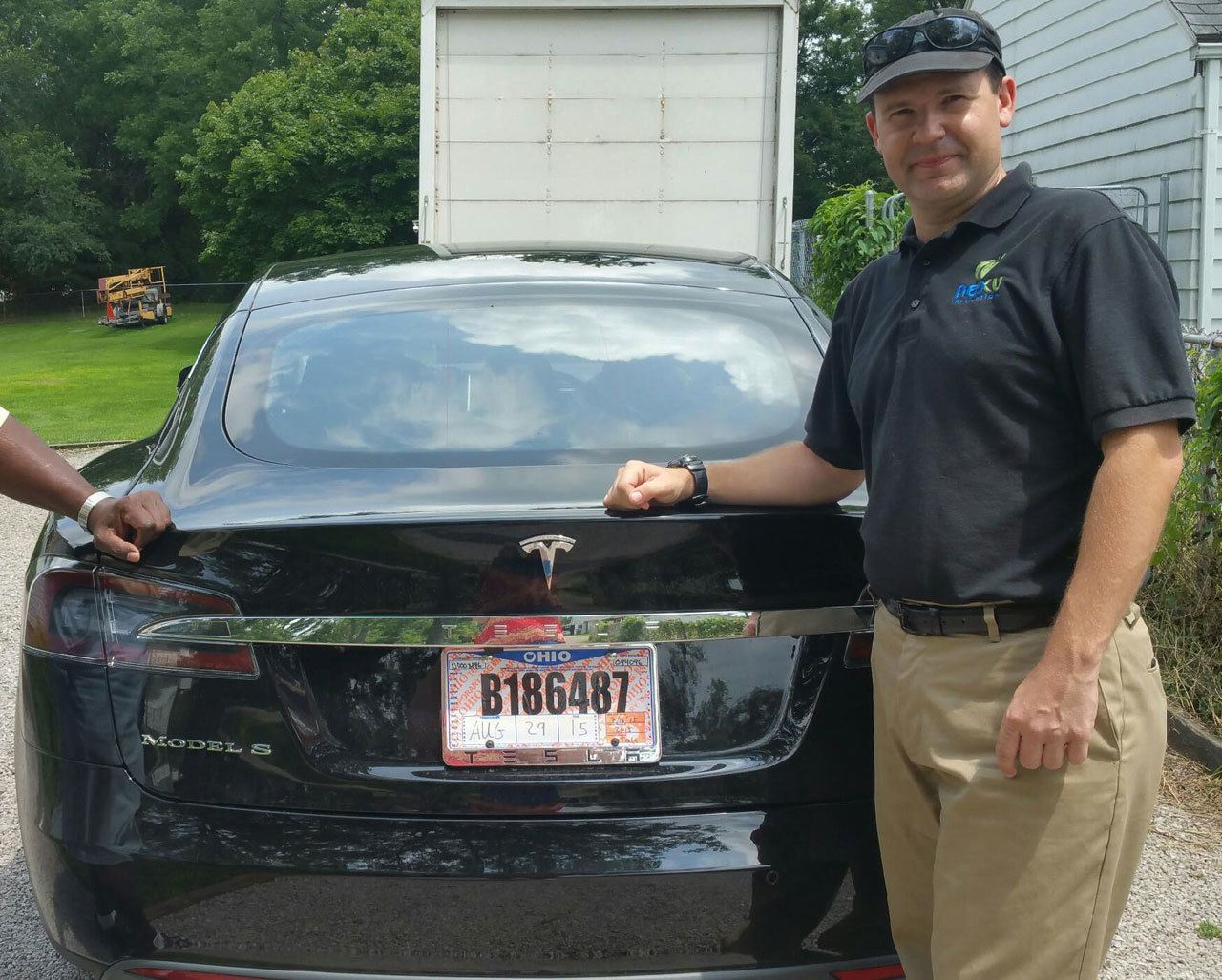 In this 2015 photo provided by his neighbor, Joshua Brown stands by his new Tesla electric car near his home in Canton, Ohio. Brown died in an accident in Florida on May 7 in the first fatality from a car using self-driving technology. (Krista Kitchen via AP, File)