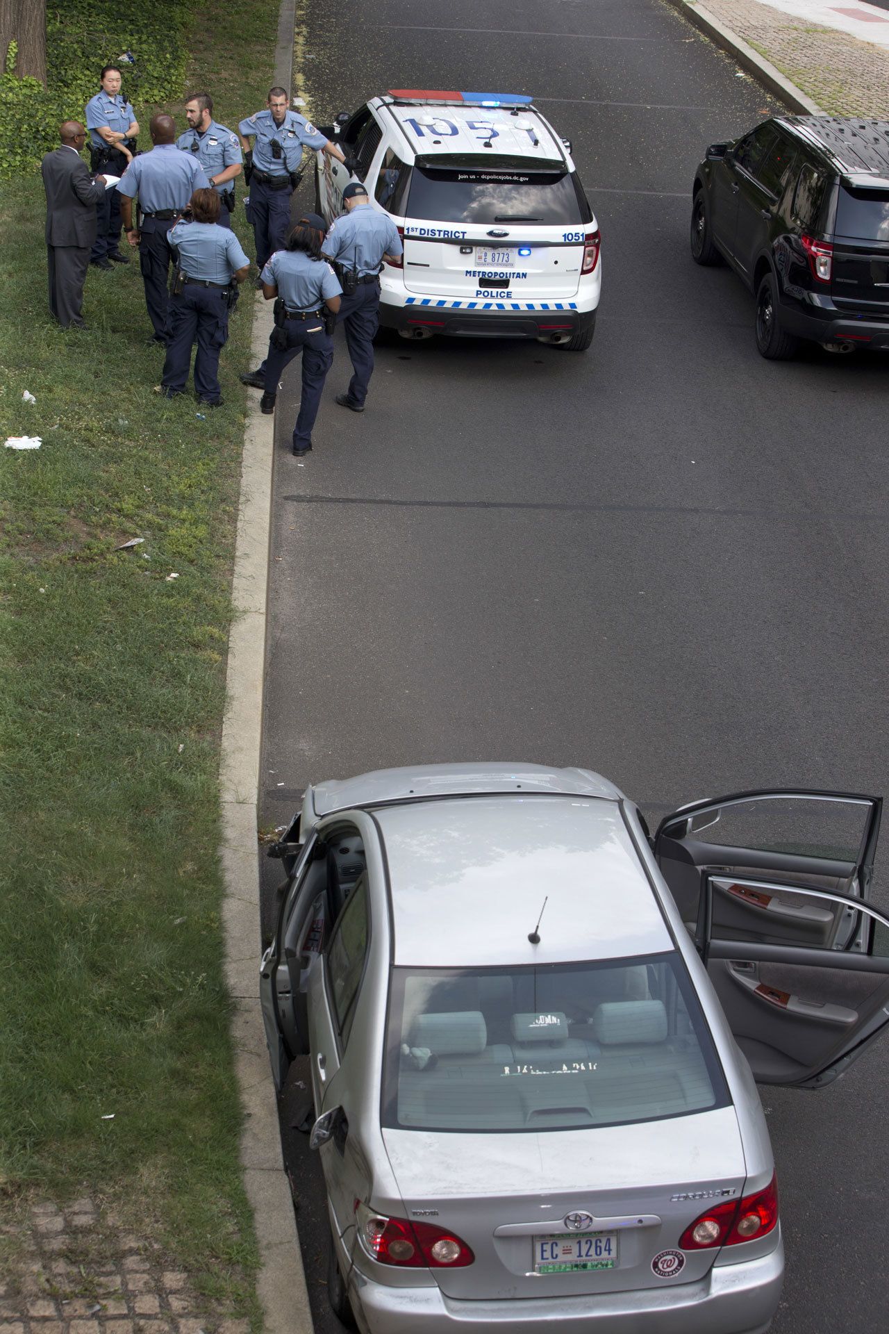 As police officers gather in the background, a car sits with its doors open near the U.S. Capitol in Washington on Tuesday. The U.S. Capitol and its office buildings were briefly locked down after District of Columbia police stopped the car about two blocks from the Capitol and took three people into custody, Police Chief Cathy Lanier told reporters at the scene. AP Photo/Jacquelyn Martin)