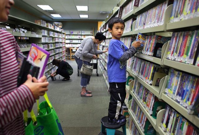 In 2015, Dian Dody needed to stand on a stool to reach a book he wanted from the shelves at the Evergreen Branch of the Everett Public Library. (Herald file photo)