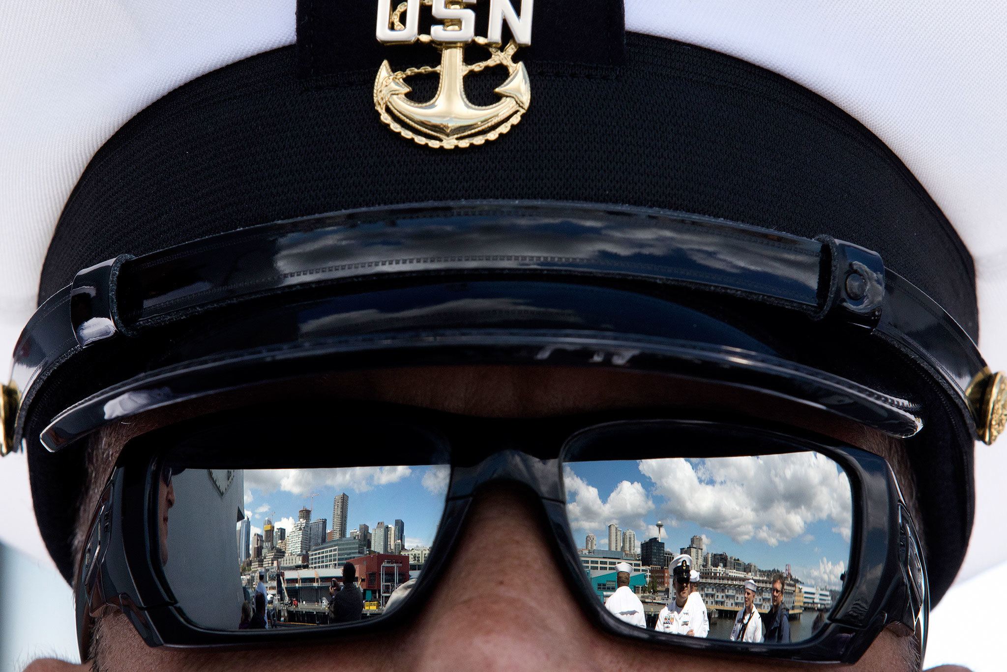 Seattle is reflected in the sunglasses of Chief Scott Altis as the USS Gridley, the newest guided missile destroyer to be based at Naval Station Everett, docks in Seattle for Seafair on Tuesday. (Andy Bronson / The Herald)