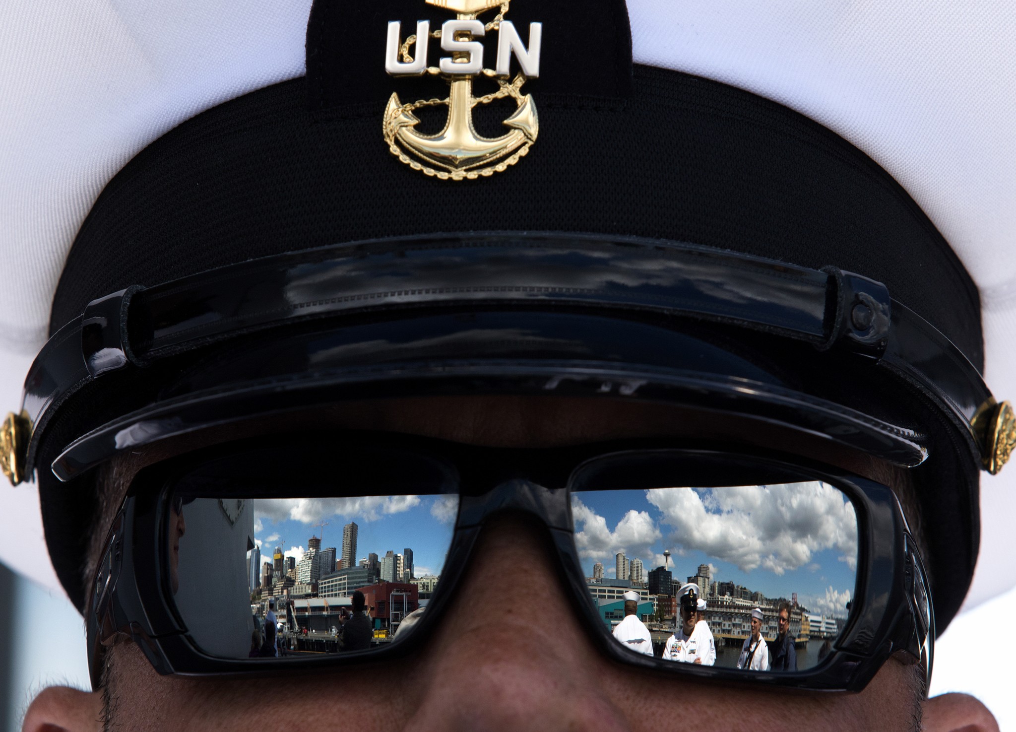 Seattle is reflected in the sunglasses of Chief Scott Altis as the USS Gridley, the newest guided missile destroyer to be based at Naval Station Everett, docks in Seattle for Seafair on Tuesday in Seattle, Wa. (Andy Bronson / The Herald)