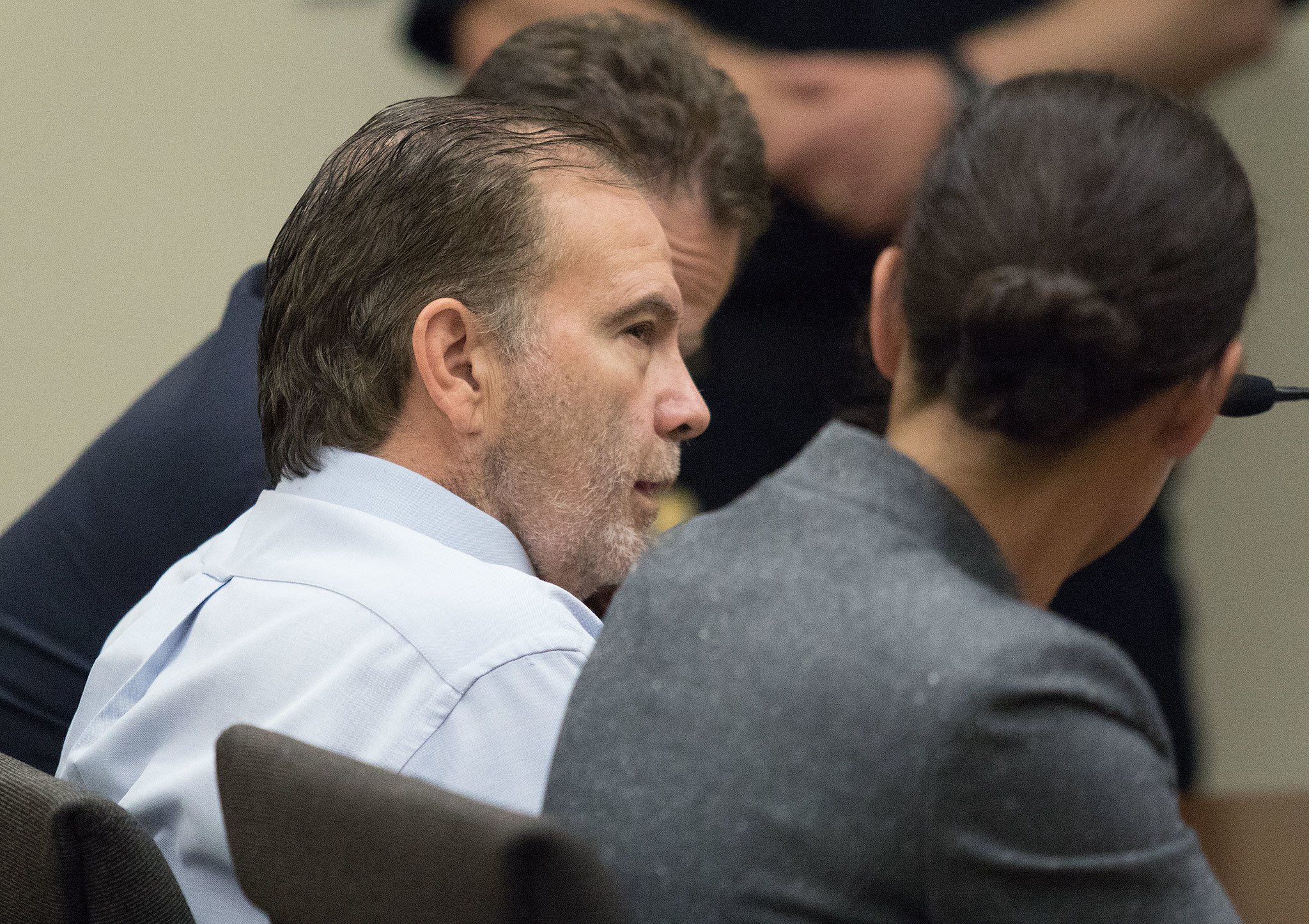 John Blaine Reed talks to his public defenders Whitney Rivera, right, and Paul Thompson during his arraignment at Snohomish County Courthouse, on two counts of aggravated murder for the killings of his former neighbors Patrick Shunn and Monique Patenaude, on Monday, Aug. 8, 2016 in Everett, Wa. His trial is scheduled for April 2017. (Andy Bronson / The Herald)