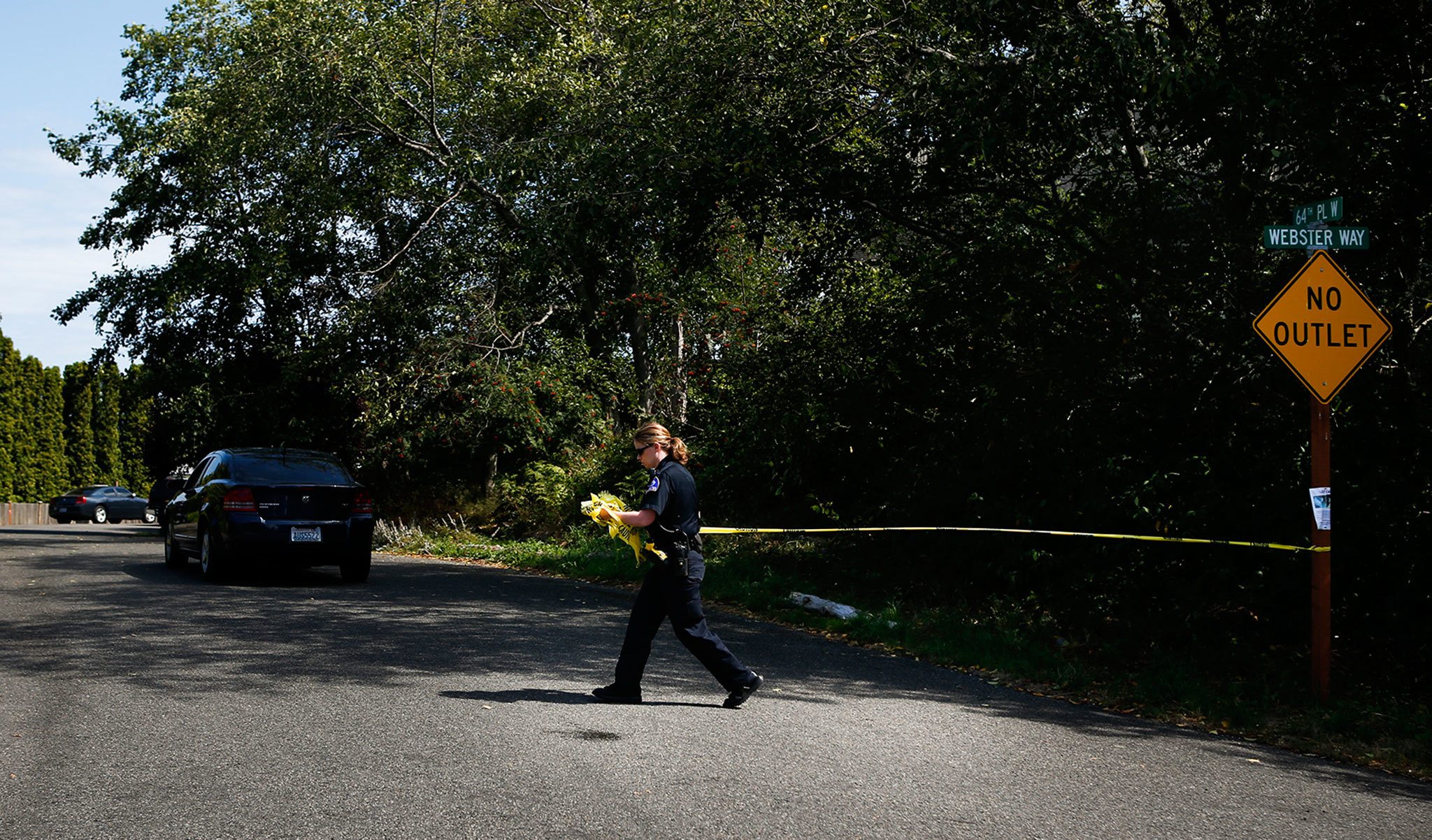 A police officer cordones off 64th Place West in the Chennault Beach area of Mukilteo on July 30 after shootings at a home there left three dead and one injured. (Ian Terry / The Herald)