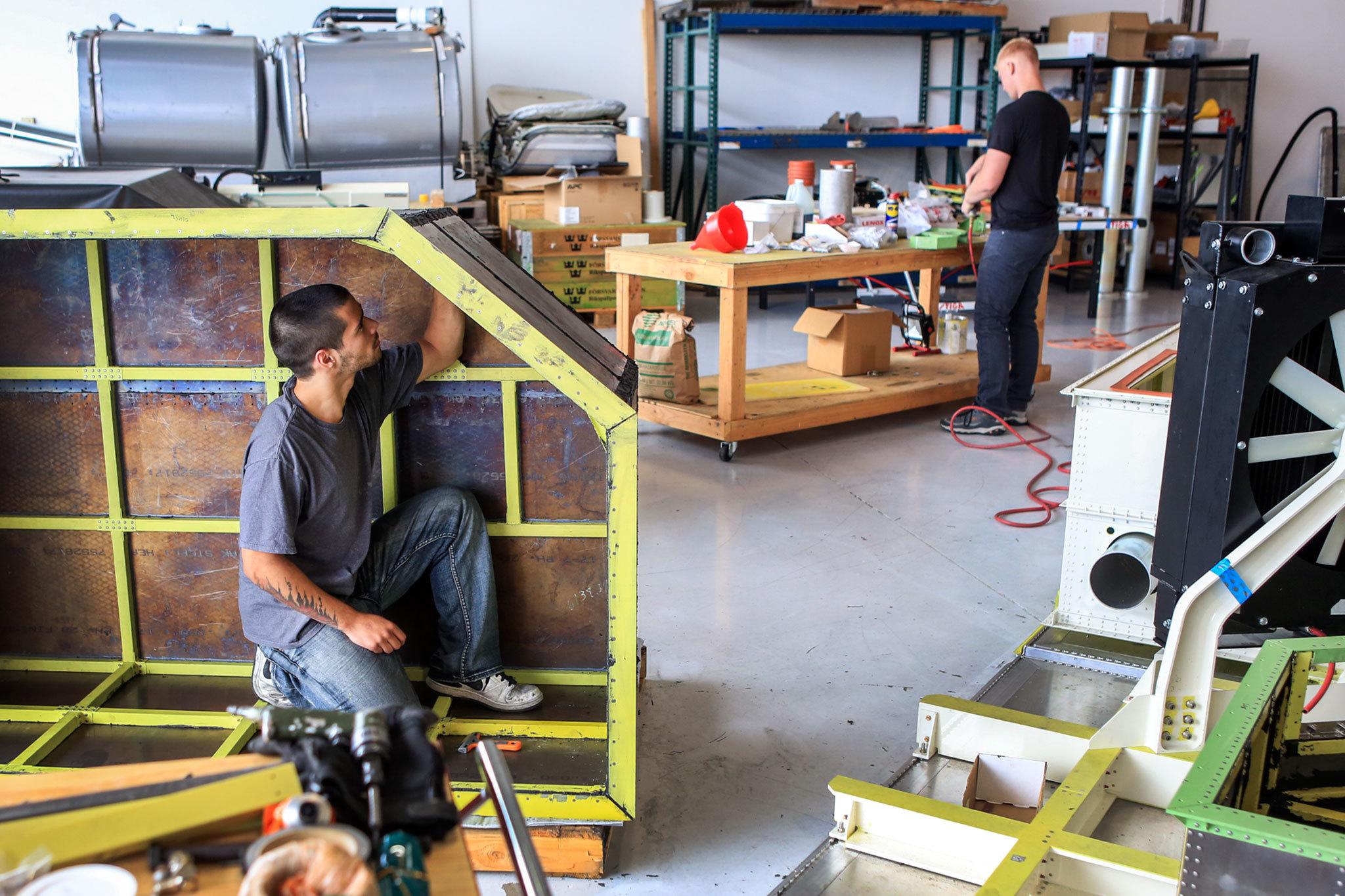Kevin Clark / The Daily Herald                                Grant Guadamuz, left, works on an upper containment pan with Kyle Fosso, right, Wednesday morning at Waypoint Aeronautical at Paine Field in Everett on August 10, 2016.