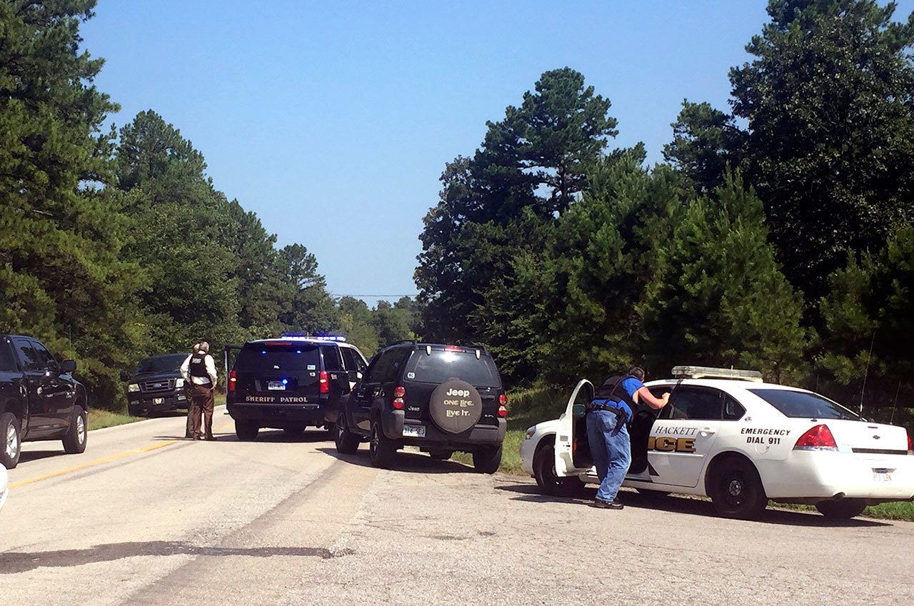 Law enforcement block an intersection during a stand off after two officers were shot — one of whom died — in Sebastian County in Western Arkansas on Wednesday. (Michael Woods/The Northwest Arkansas Democrat-Gazette)