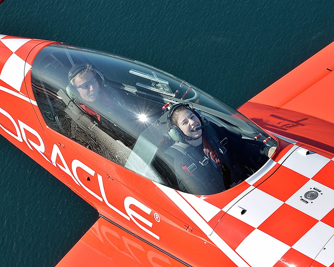 Kelly Howell, 16, of Lake Stevens, in the front seat of a stunt plane with famous pilot Sean D. Tucker flying above Puget Sound on Aug. 4. (Jeff Cook / Live-N-Loud Photography)