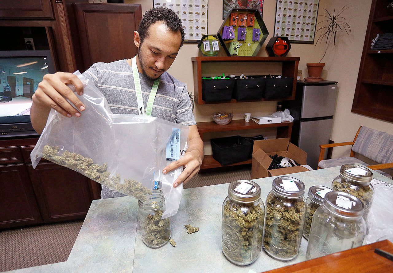 Miles Claybourne sorts strains of marijuana for sale at The Station, a retail and medical cannabis dispensary, in Boulder, Colorado, on Thursday. (AP Photo/Brennan Linsley)