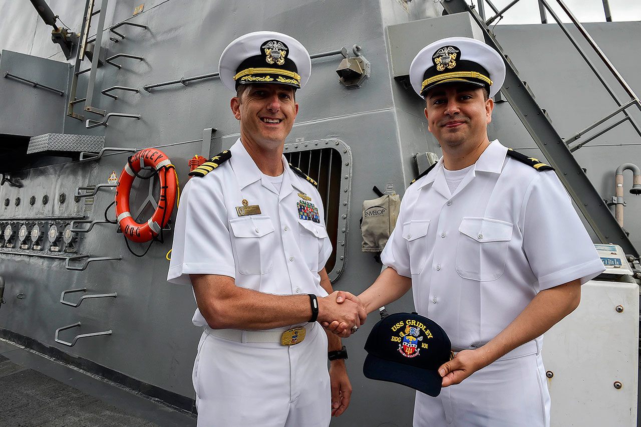 Cmdr. Marc Crawford, commanding officer aboard the USS Gridley, presents a cap to Navy Recruiting District Seattle’s newest Ensign, Arman Salimi, from Bothell, during Seattle Seafair Fleet Week 2016. (U.S. Navy photo by Mass Communication Specialist 1st Class Cory Asato)
