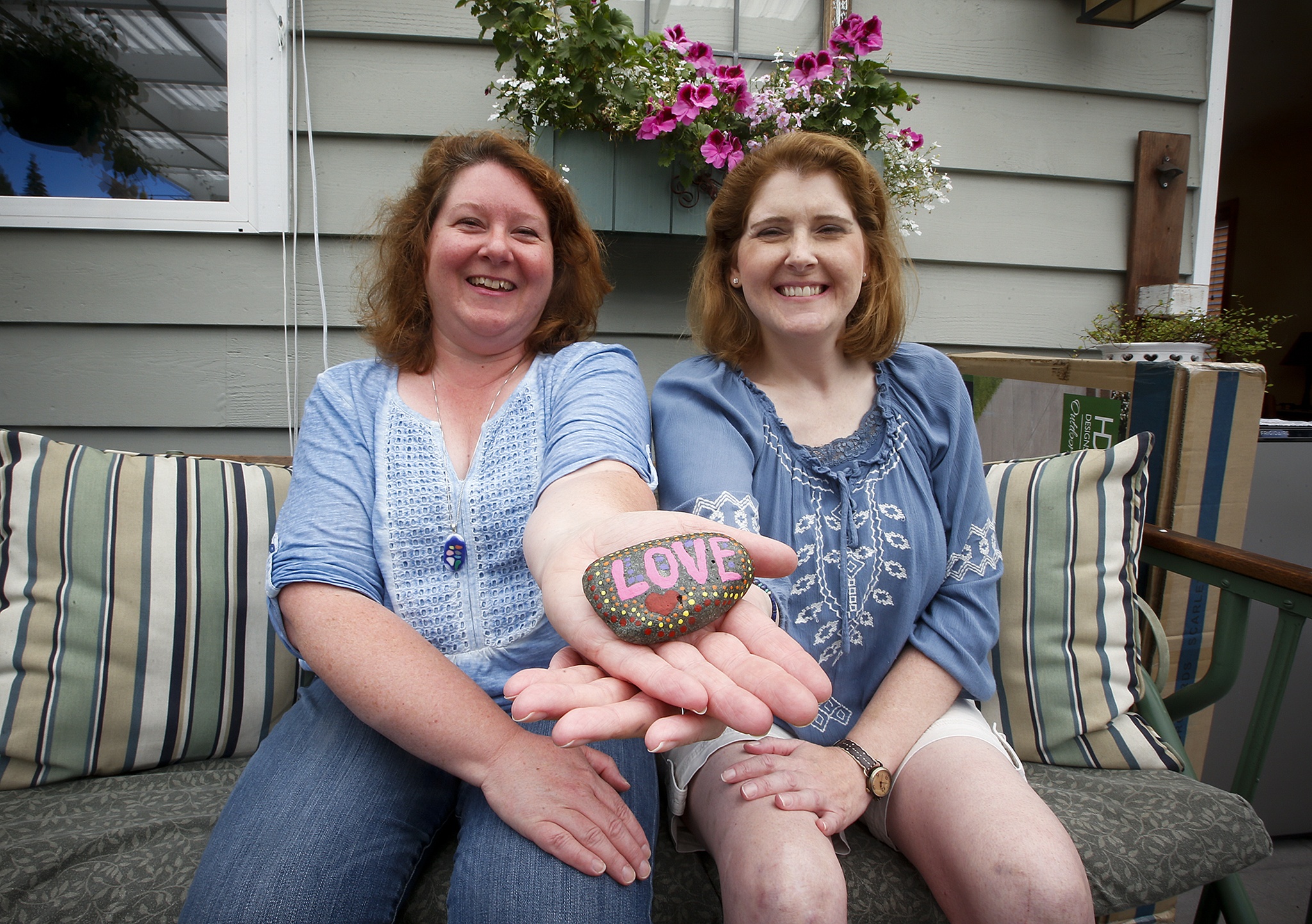 Sisters Jennifer (left) and Jill Nelson have painted and distributed about 75 rocks so far throughout Edmonds as part of their “Edmonds Rocks” group which aims to bring a little joy into the lives of people who stumble upon their creations. “The kids get so excited when they find something they like,” Jennifer Nelson said. (Ian Terry / The Herald)