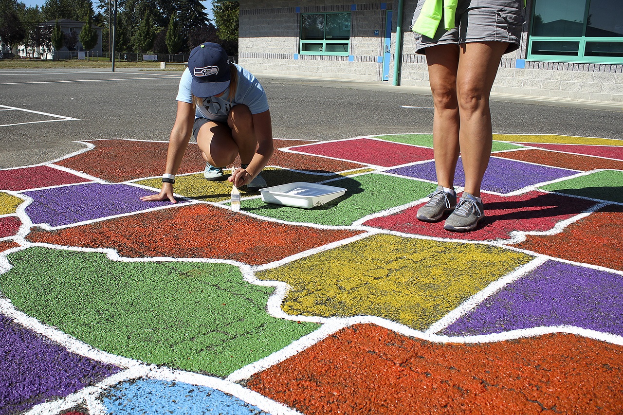 Volunteers from The Grove Church in Marysville paint a new map on the grounds of Allen Creek Elementary School in Marysville as part of their 2016 iheart effort to connect and better their community. (Courtesy of Tori Downey)
