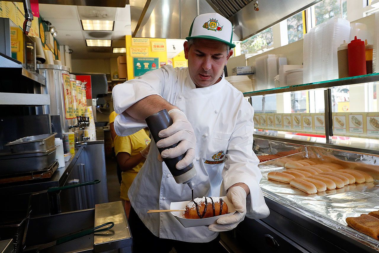 Papaya King president Wayne Rosenbaum spreads chocolate sauce on a freshly deep-fried Twinkie at the flagship store in New York on Aug. 3. (AP Photo/Mary Altaffer)