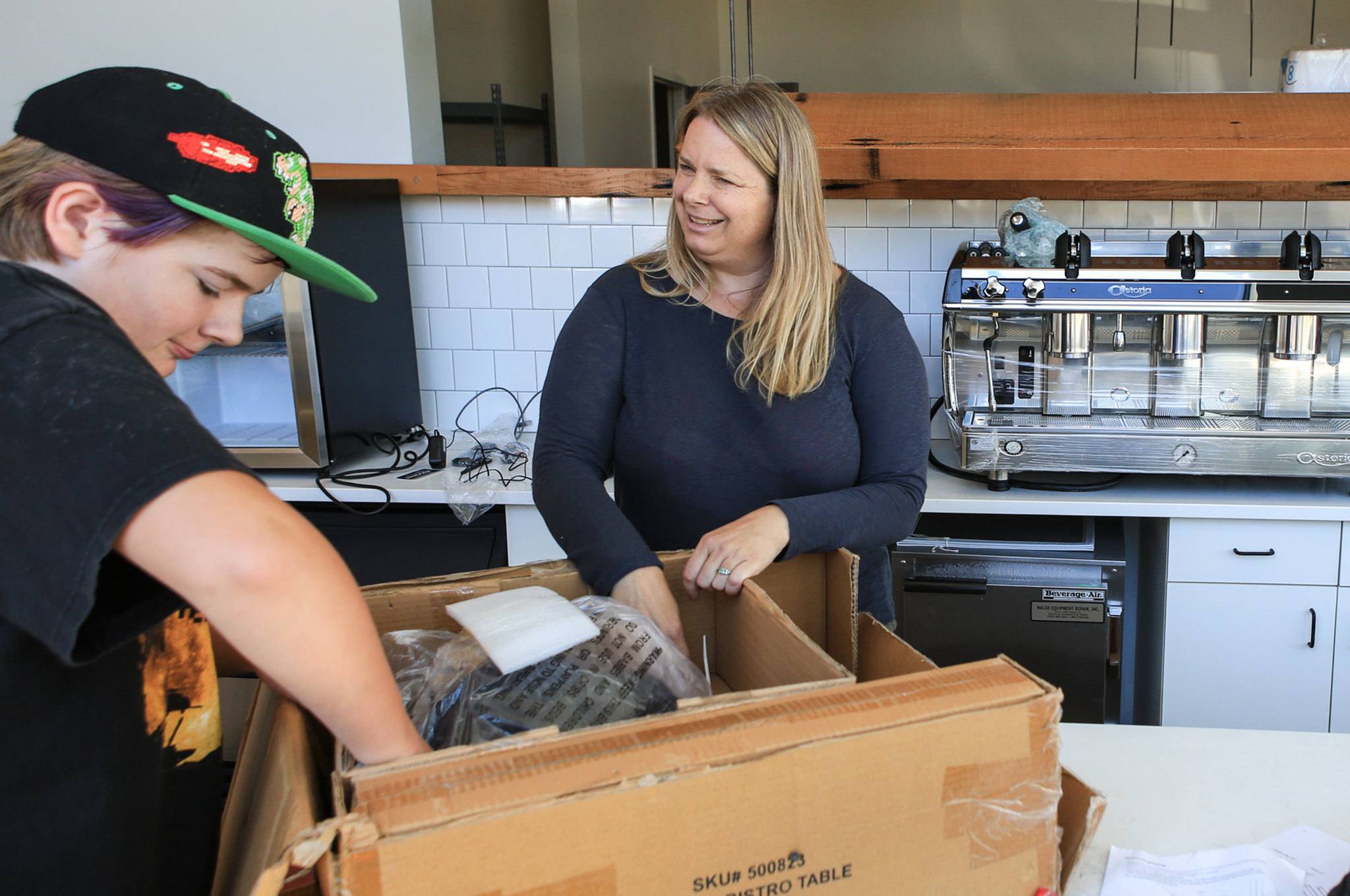 Soren Schreffler (left) and Rachel Schreffler work to assemble tables at Choux Choux Bakery at Potala Place. A federal court is considering a plan to complete the commercial space at Potala Place, a 220-unit apartment building in downtown Everett. (Kevin Clark / The Herald)