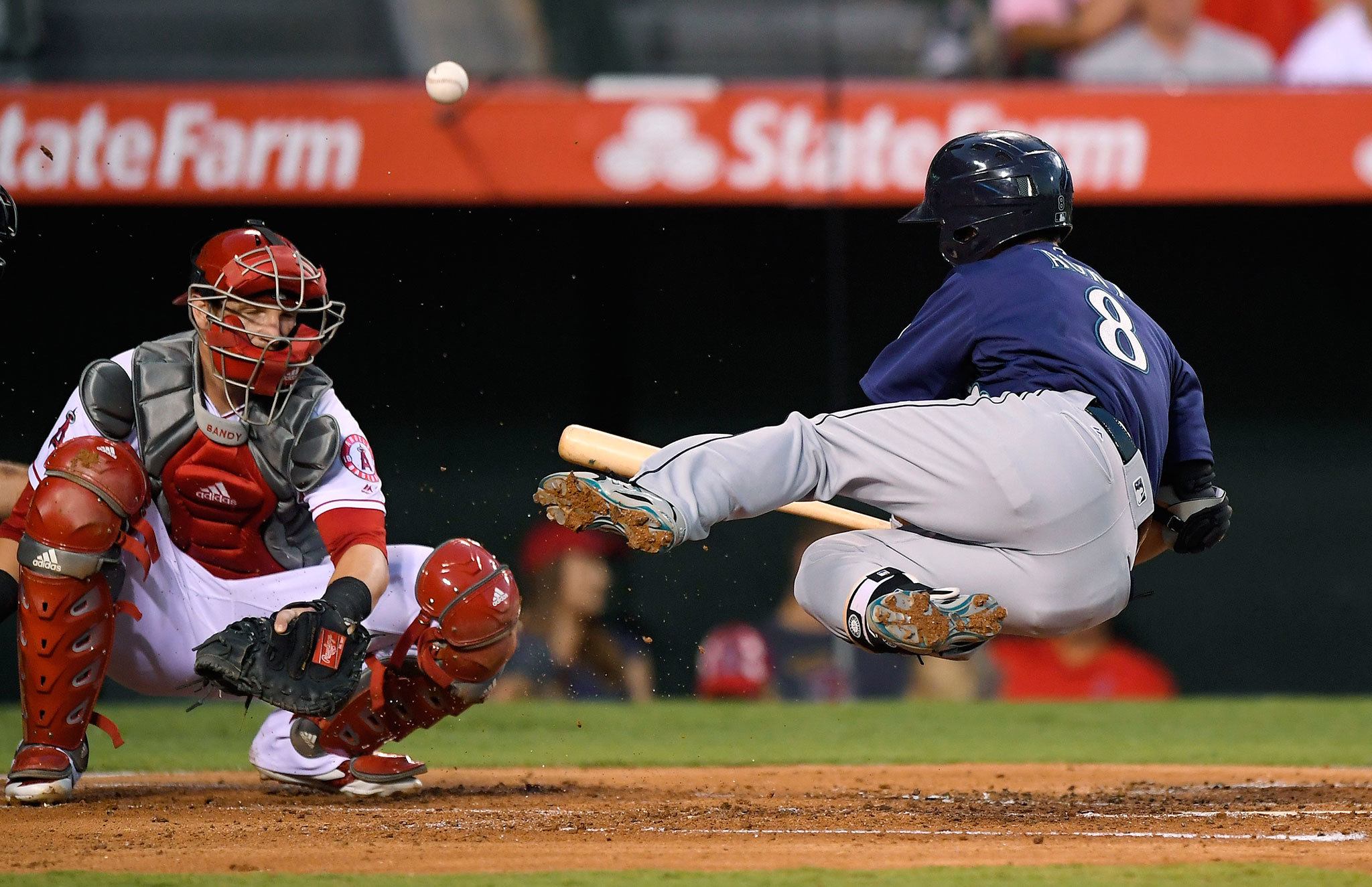 The Mariners’ Nori Aoki is hit by a pitch as Angels catcher Jett Bandy looks on during the second inning of Tuesday’s game. (AP Photo/Mark J. Terrill)