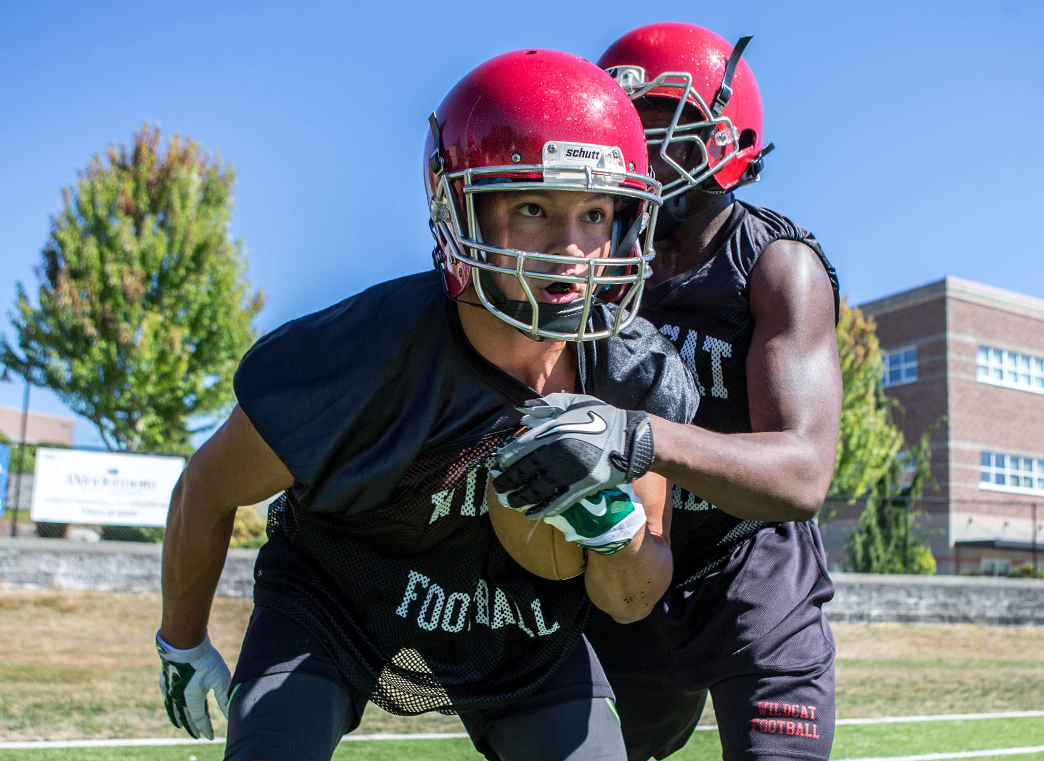 Collin Montez (left) works to keep possession of the ball with Emmanuel Osuoha reaching in during the first day of football practice Wednesday at Archbishop Murphy High School. Montez, the former Marysville Getchell standout running back, transferred for his senior year. (Kevin Clark / The Herald)