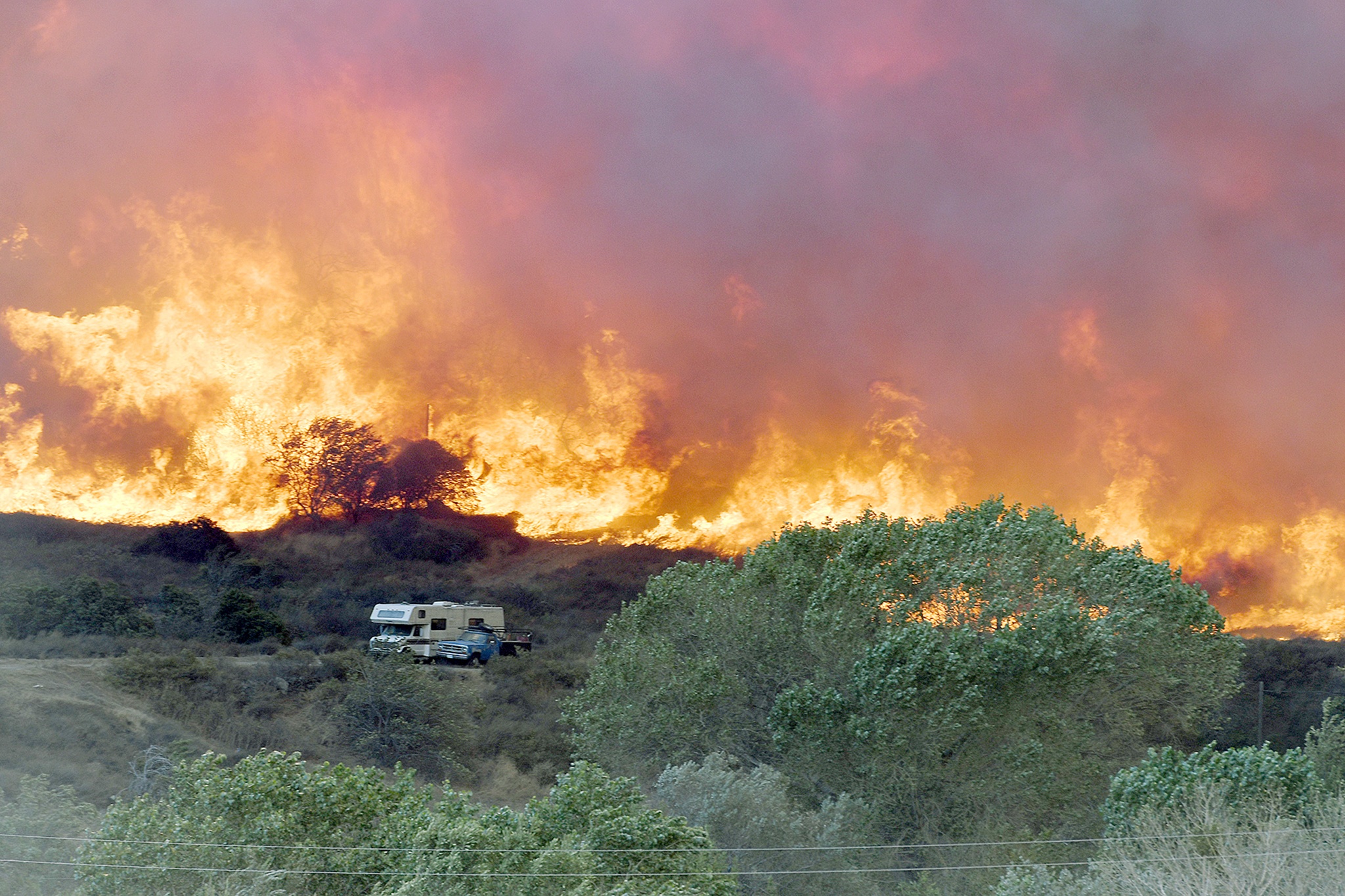 Flames from the Bluecut Fire approach an RV and a vehicle in Devore, California, on Wednesday. (David Pardo/The Victor Valley Daily Press via AP)