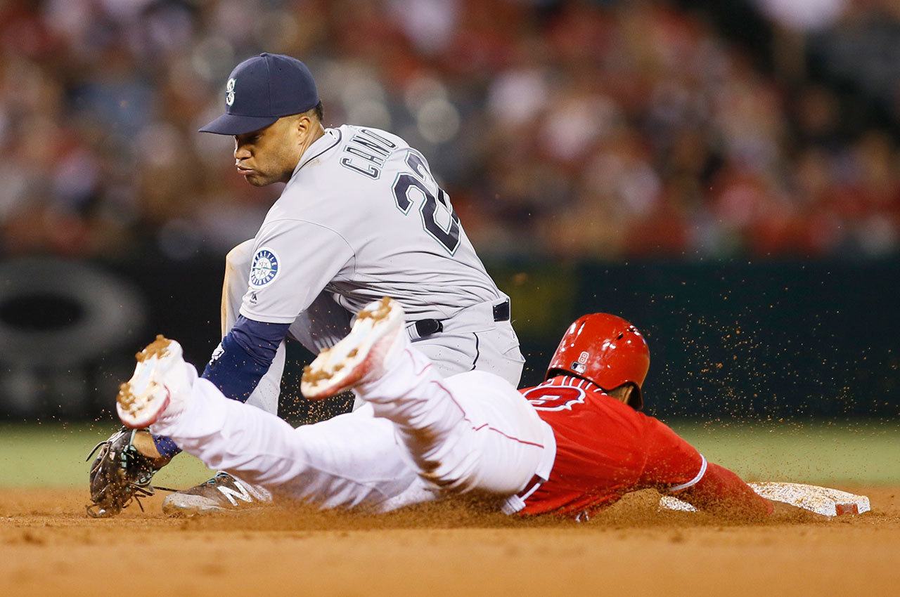Mariners second baseman Robinson Cano (left) catches the throw before before tagging out the Angels’ Gregorio Petit on a steal attempt to end the second inning Wednesday in Anaheim, Calif. (AP Photo/Danny Moloshok)