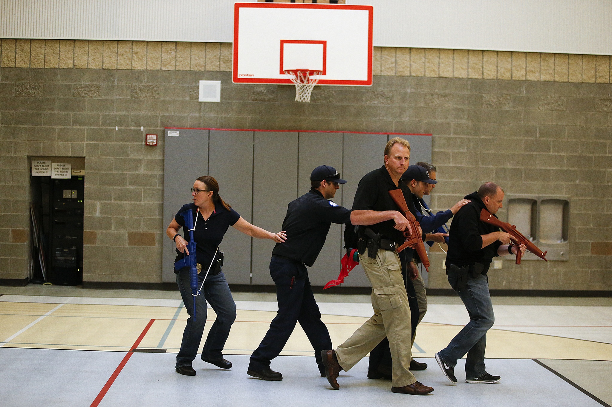 A group of Marysville police practice a “diamond” formation to protect Marysville fire department personnel during training at Grove Elementary School in Marysville on Aug. 9. Under new protocol, paramedics will be escorted by law enforcement into a “warm zone”, an area checked by but still considered dangerous by police, to provide critical care within the first hour of a mass casualty event. (Ian Terry / The Herald)