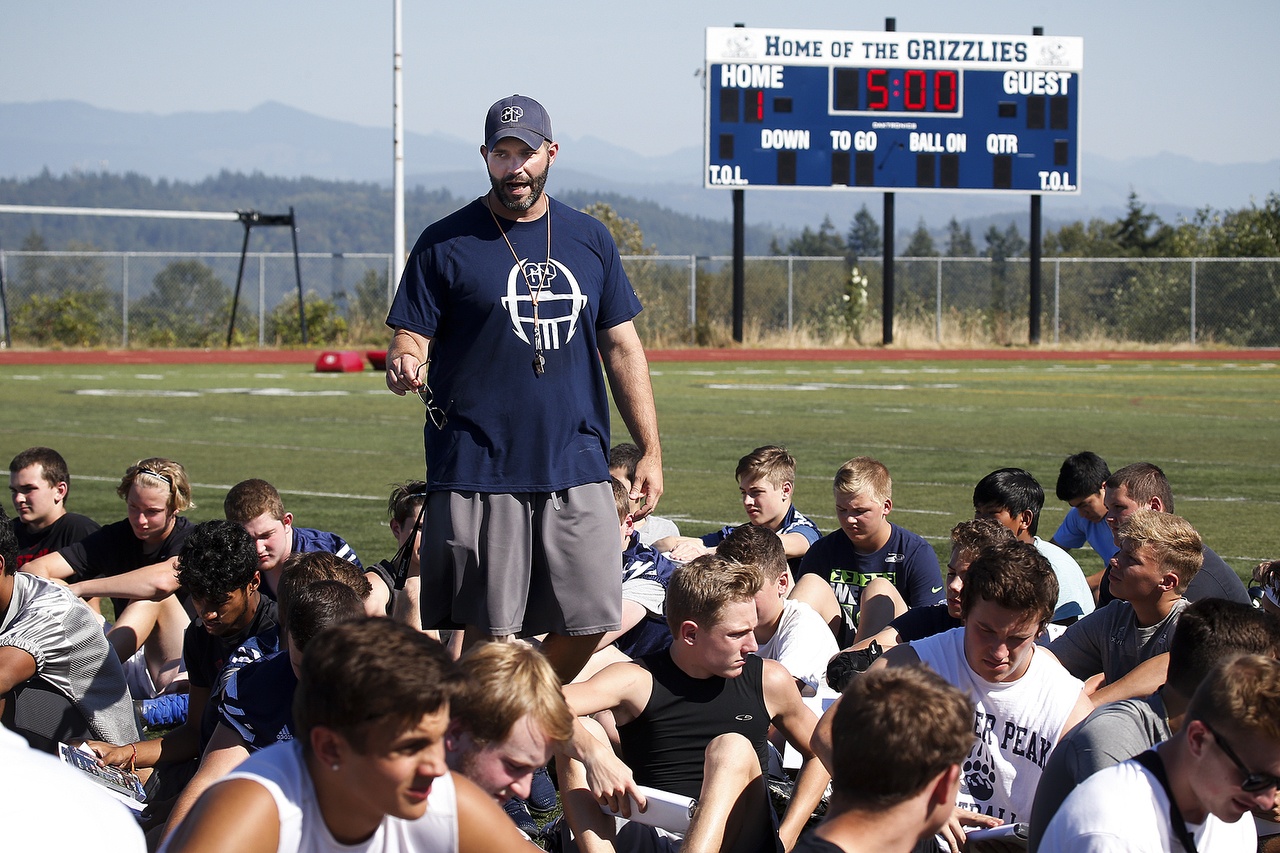 Glacier Peak football coach Nick Bender talks to his team before practice Friday afternoon in Snohomish. This season, Bender replaces Rory Rosenbach, who had been the only coach in the history of Grizzlies football. (Ian Terry / The Herald)