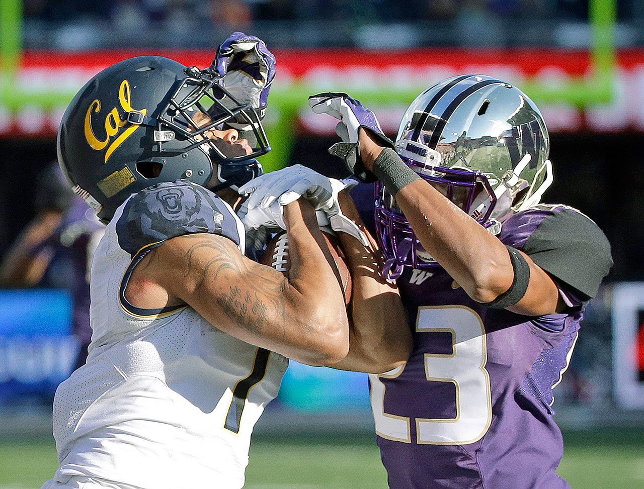 California’s Bryce Treggs (left) fights for control of a pass with Washington’s Jordan Miller during the Golden Bears’ win in Seattle last September. Miller has been a bright spot of UW’s fall camp. (AP Photo/Elaine Thompson)