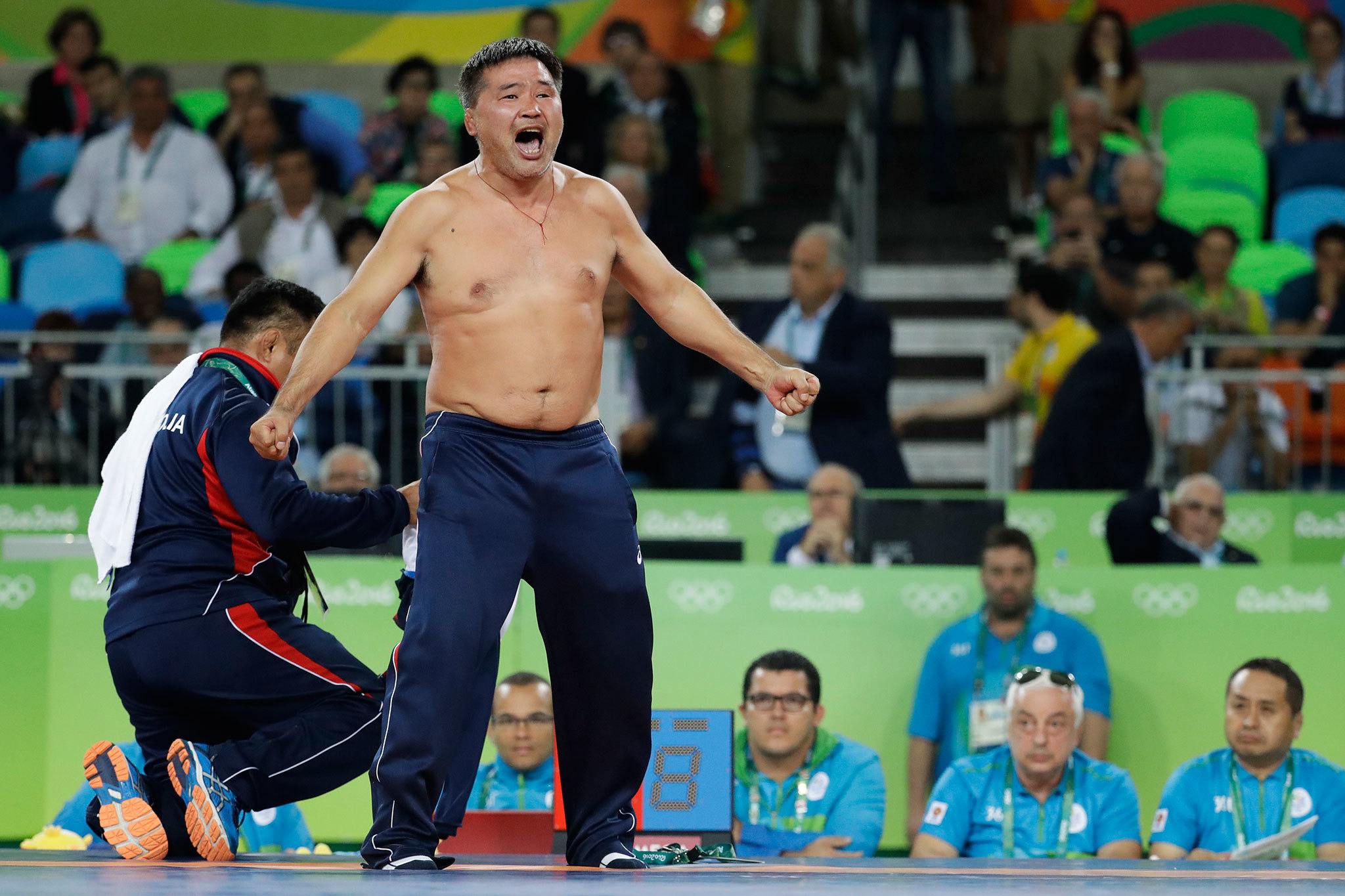 Coaches of Mongolia’s wrestler Mandakhnaran Ganzorig take off their clothes in protest against the decision of the jury to award the bronze medal to Uzbekistan’s Ikhtiyor Navruzov during the men’s 65-kg freestyle wrestling competition at the 2016 Summer Olympics in Rio de Janeiro on Sunday. (AP Photo/Markus Schreiber)
