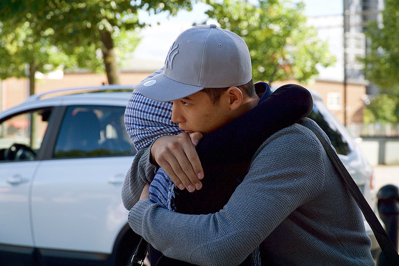 In this Aug. photo, Mahdi Azizi hugs his mother goodbye before boarding a bus to return to a centre for unaccompanied minors, in Vasteras, Sweden. (AP Photo/David Keyton)