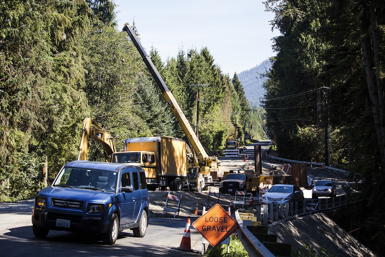 A line of cars makes its way past construction for the Cranberry Creek culvert replacement project at milepost 8 along the Mountain Loop Highway on Friday, Aug. 19, 2016 just outside Granite Falls, Wa. The new culvert, a 20-foot-wide concrete water crossing, will open up the crossing for trout and salmon migration. (Daniella Beccaria / For The Herald)