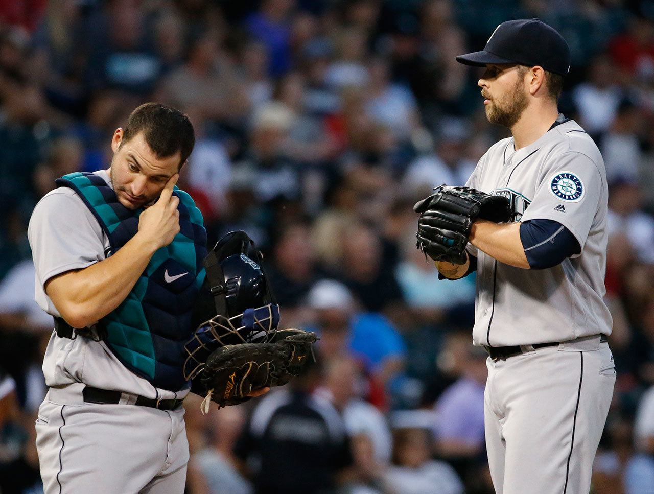Mariners catcher Mike Zunino (left) wipes his face as he listens to starter James Paxton during the first inning of a game Thursday against the White Sox in Chicago. (AP Photo/Nam Y. Huh)