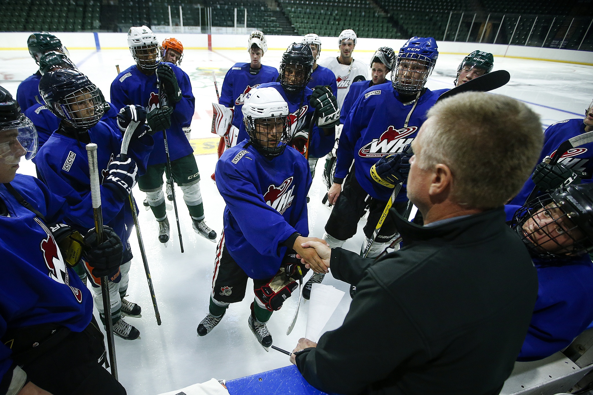 John Lee (center) shakes hands with Silvertips head coach Kevin Constantine following the first day of training camp Thursday at Xfinity Arena in Everett. (Ian Terry / The Herald)