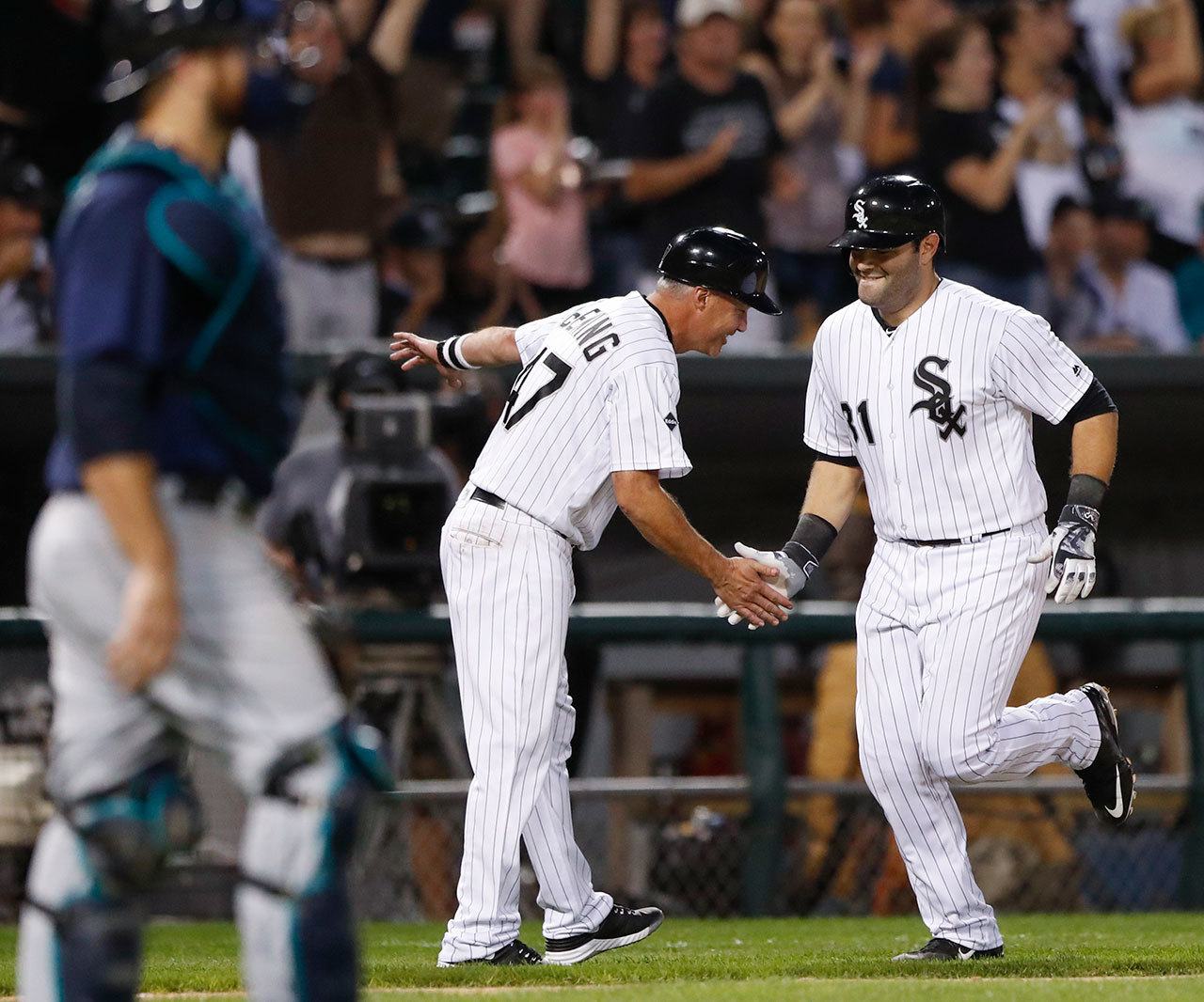 The White Sox’ Alex Avila (right) celebrates with third base coach Joe McEwing after hitting a home run off the Mariners’ Vidal Nuno during the fifth inning of a game Saturday in Chicago. (AP Photo/Kamil Krzaczynski)