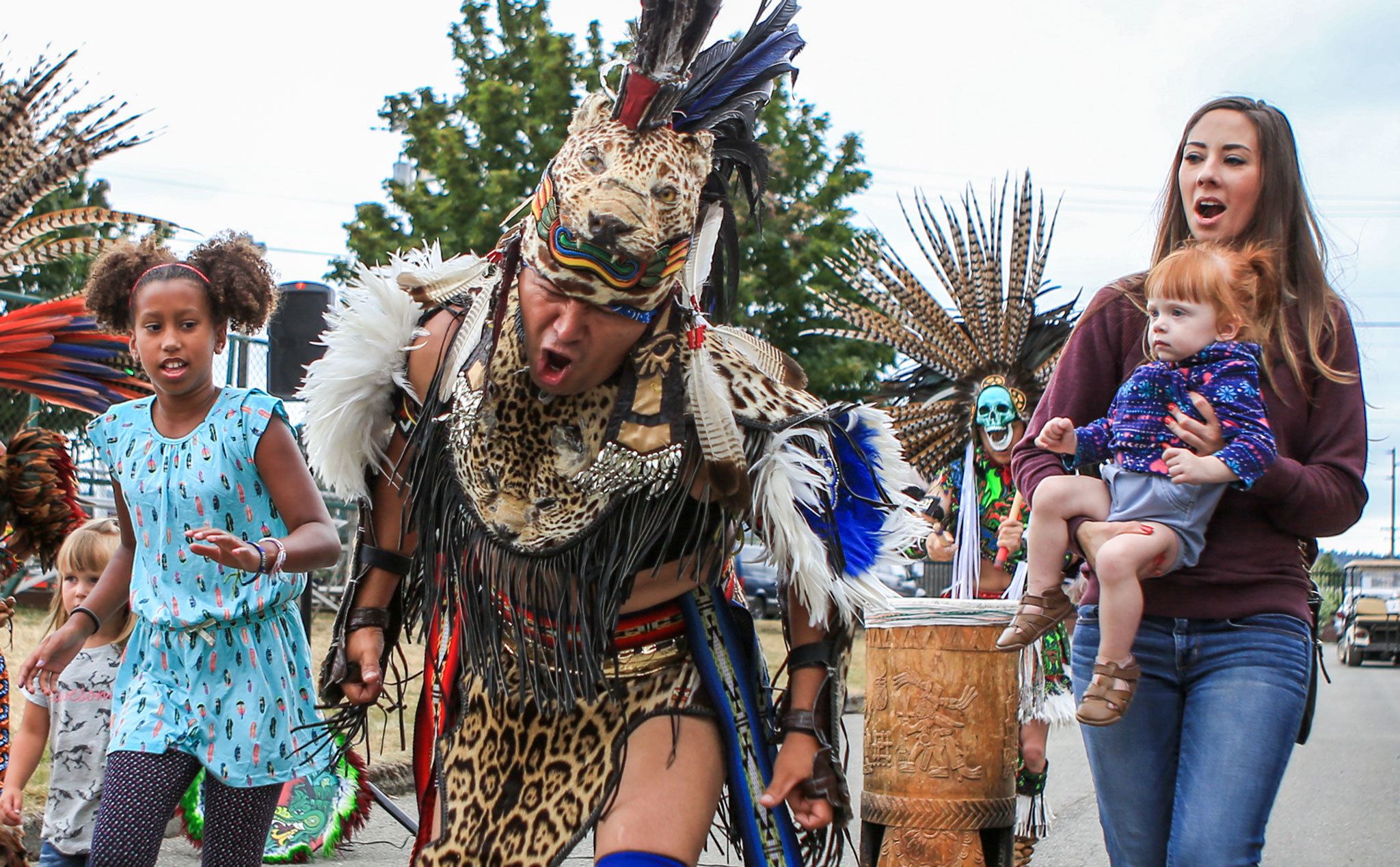 Jose Salinas, center, leads an Aztec Indian dance with Kiana Kypreos. left, and Kerry Wood holding Sophia Wood, right, following along Saturday afternoon during the annual Evergreen State Fair in Monroe. The 12-day fair runs through Labor Day and is one of the largest events held in the Pacific Northwest. (Kevin Clark / The Herald)