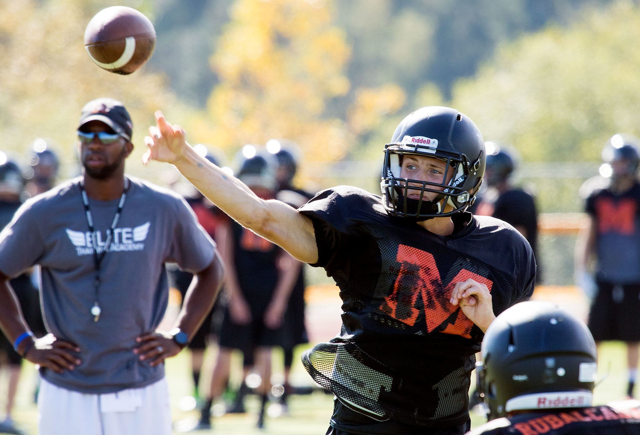 Monroe quarterback Zach Zimmerman throws a pass under the watchful eye of head coach Michael Bumpus during practice on Monday. (Andy Bronson / The Herald)