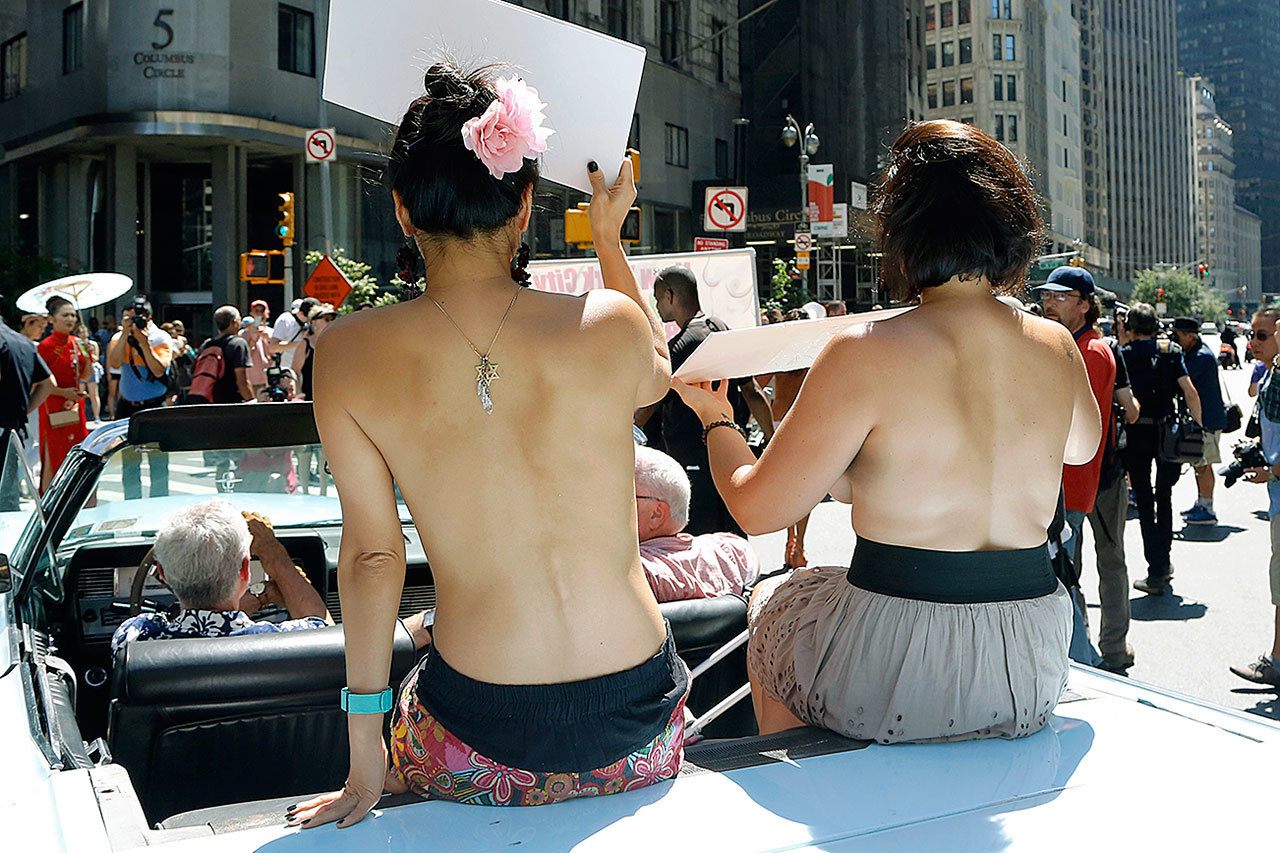 Participants ride in a convertible Sunday through midtown Manhattan in the GoTopless Pride Parade in New York. GoTopless Day is celebrated annually in the U.S., on the Sunday closest to Women’s Equality Day, marking the day American women earned the right to vote. (AP Photo/Mark Lennihan)