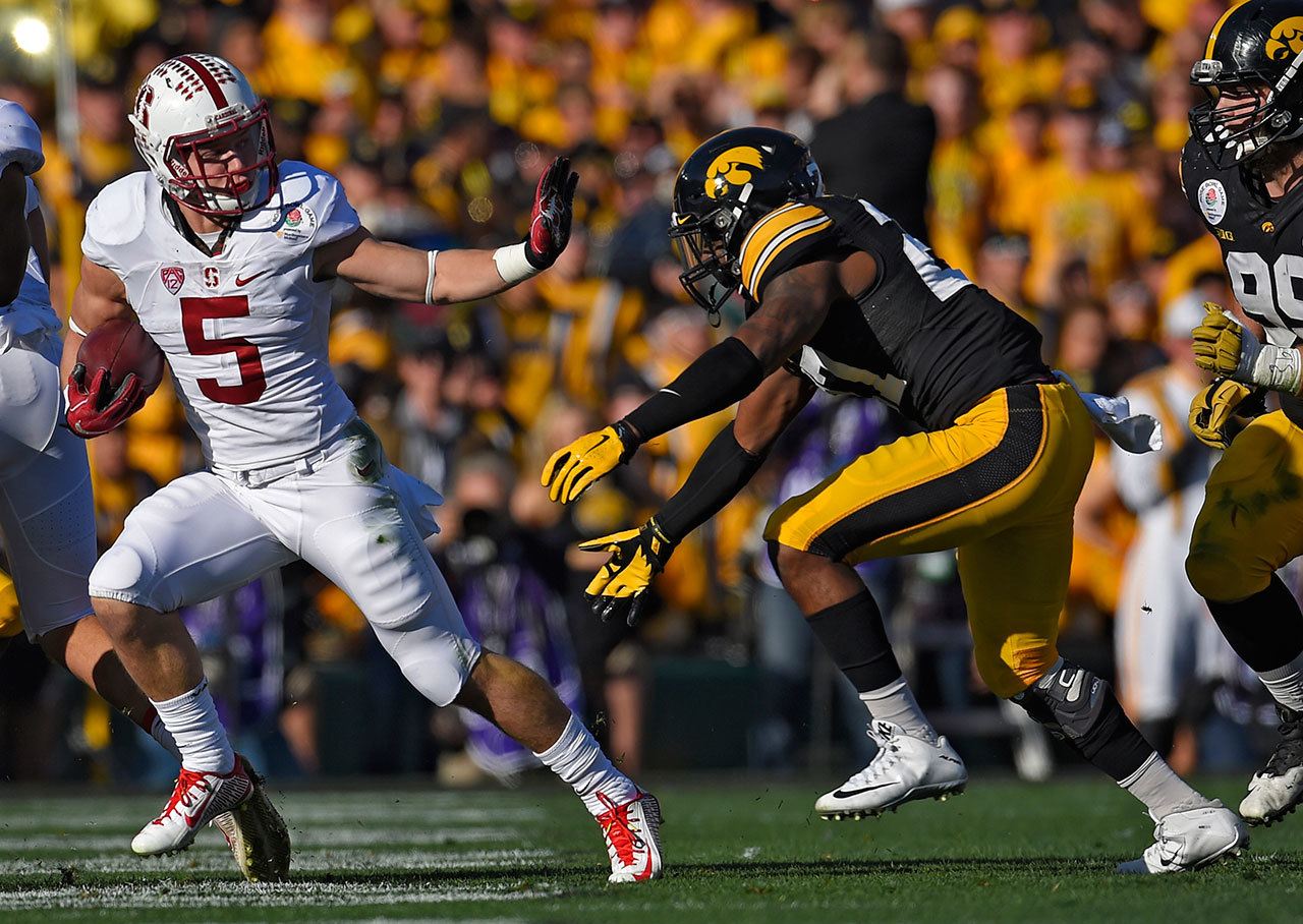 Stanford running back Christian McCaffrey (left) runs past Iowa defensive back Jordan Lomax during the Rose Bowl on Jan. 1 in Pasadena, Calif. McCaffrey and the Cardinal have a difficult schedule this season. (AP Photo/Mark J. Terrill)