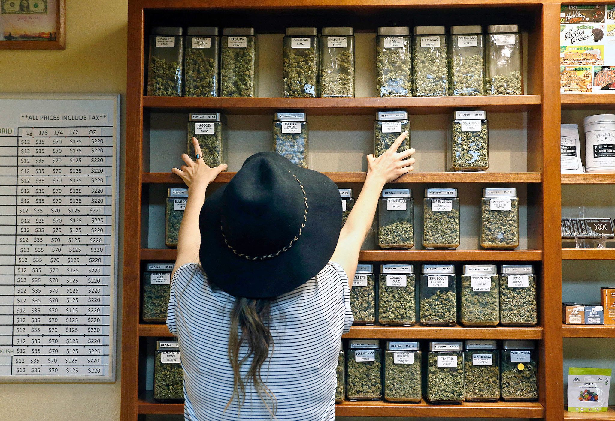 An employee arranges containers of marijuana on shelves at a retail and medical cannabis dispensary in Boulder, Colorado, on Aug. 11. (AP Photo/Brennan Linsley)