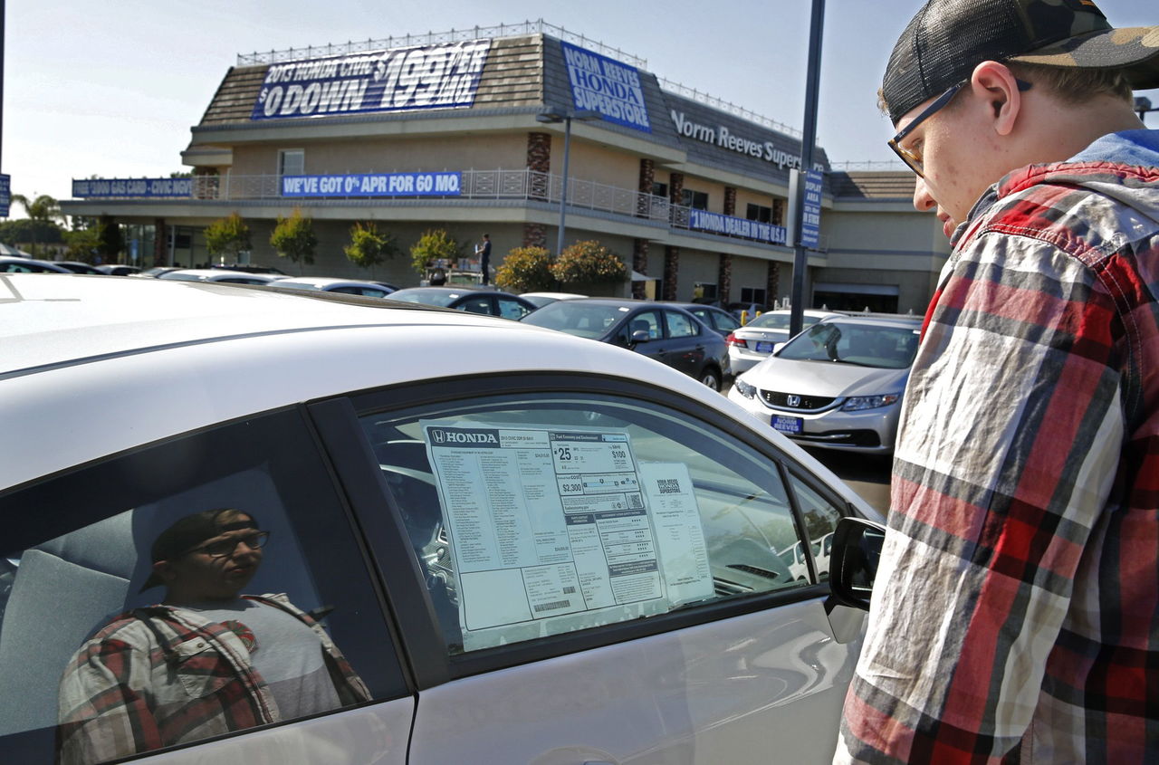 Matthew Zietara looks at a new Honda Civic at Norm Reeves Honda in Cerritos, California. Some fear that loose credit standards for car loans could backfire if there is an economic downturn.