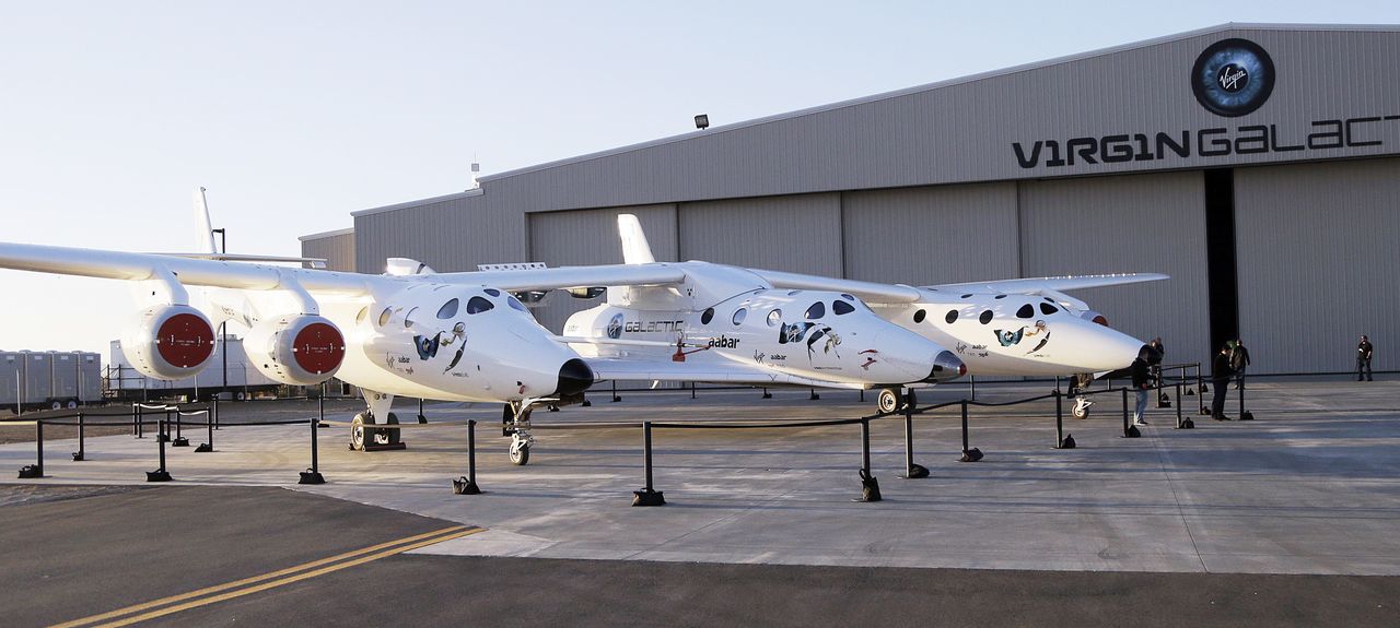 The first SpaceShipTwo is seen suspended at center beneath its twin-fuselage mother ship in Mojave, California, in 2013.