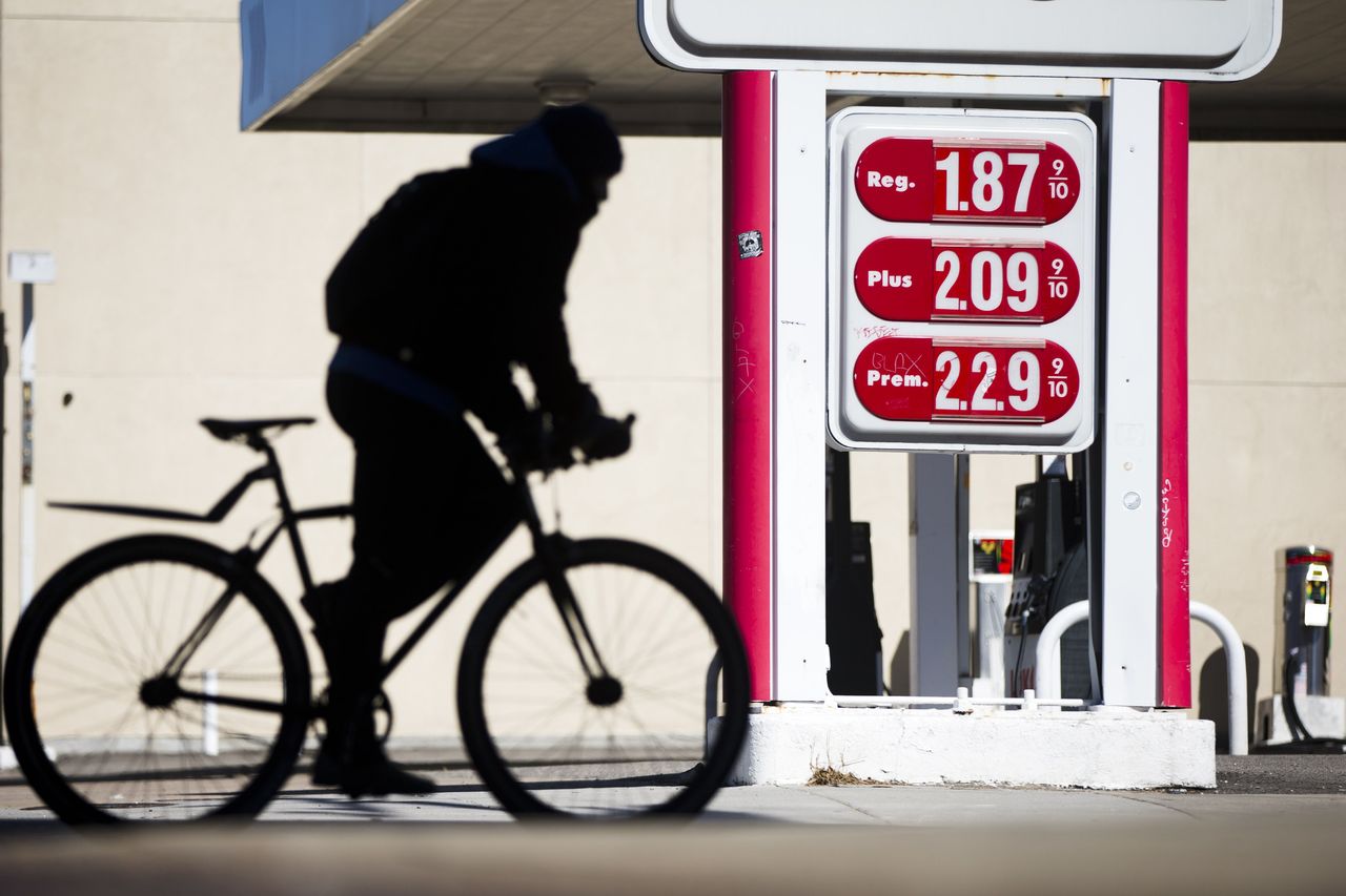 A cyclist passes posted gasoline prices at a filling station in Philadelphia on Wednesday.