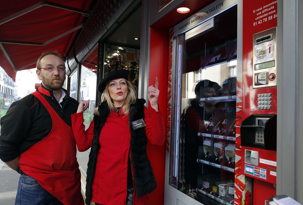 Owners Michel and Florence right Pouzol pose by the first meat vending machine installed in Paris on Tuesday.