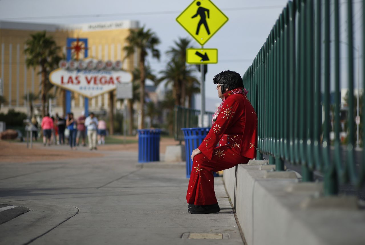 Ted Payne rests as he works for tips dressed as Elvis at the “Welcome to Las Vegas” sign in Las Vegas on March 3. For decades, Las Vegas has loved Elvis Presley. But the King’s presence in modern day Sin City has lately been diminishing.