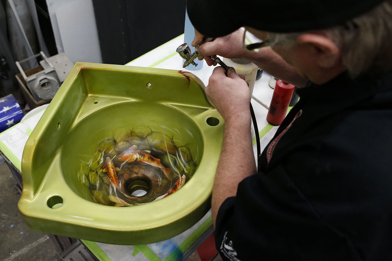 Airbrush artist Mike Lavallee works on a custom corner sink at his studio, Killer Paint, in Snohomish. Lavallee is beginning to focus more on customizing home appliances.