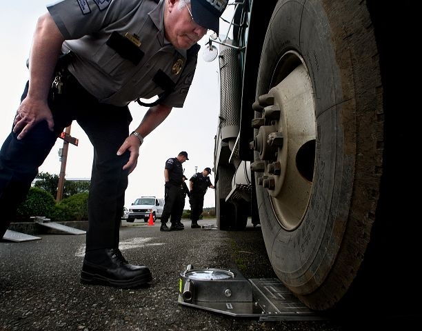 Dan Bates / The Herald File Ernie Brown, a commercial enforcement officer with the State Patrol, checks the weight of a truck during a 2007 surprise inspection in Stanwood.