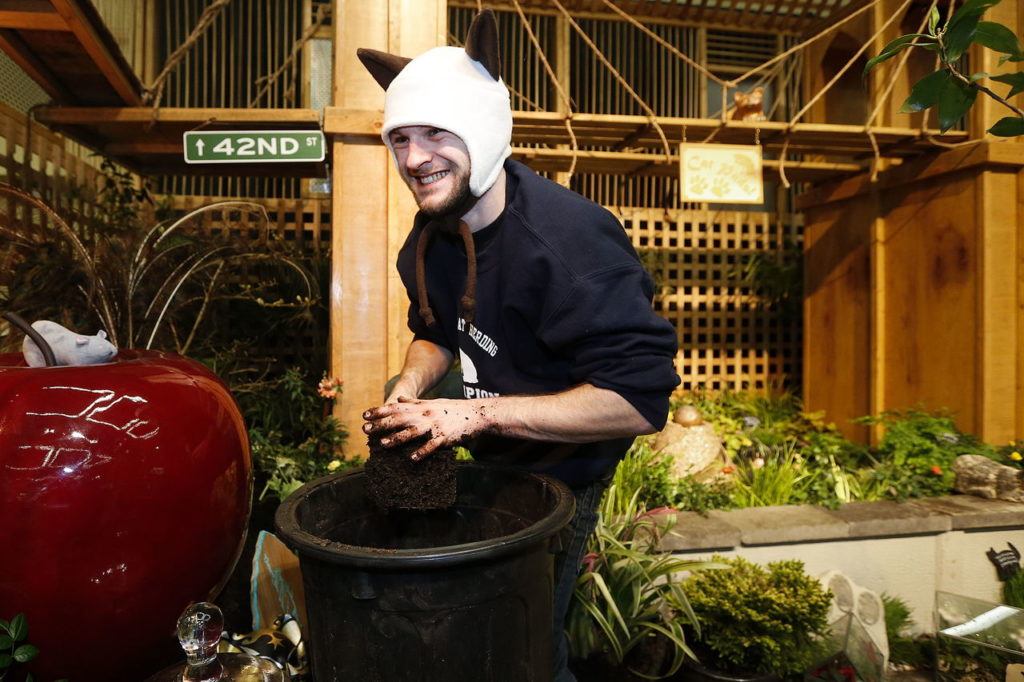 Felix Jones, son of Fancy Fronds Nursery owner Judity Jones, lays down final bits of soil at the Northwest Flower and Garden Show in Seattle.
