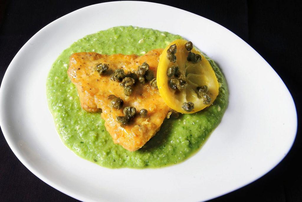 Sauteed lemon chicken and fried capers from “Sara Mouton’s Home Cooking 101” sits on sweet pea puree.

