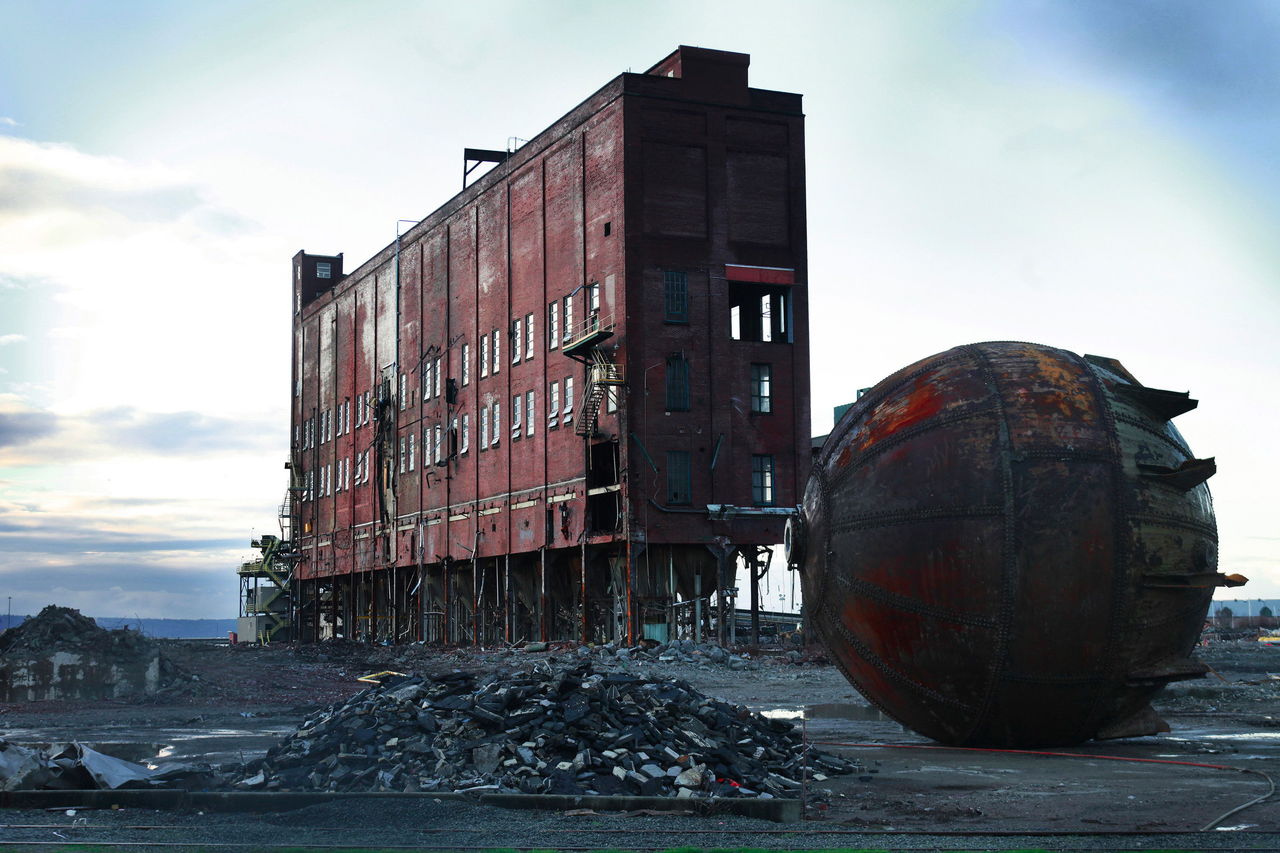 The digester building, built in the early 1930s, stands alone as destruction of the Kimberly-Clark plant continues Thursday evening. In the foreground sits a 32-foot acid accumulator. The building is scheduled to be brought down on Saturday.