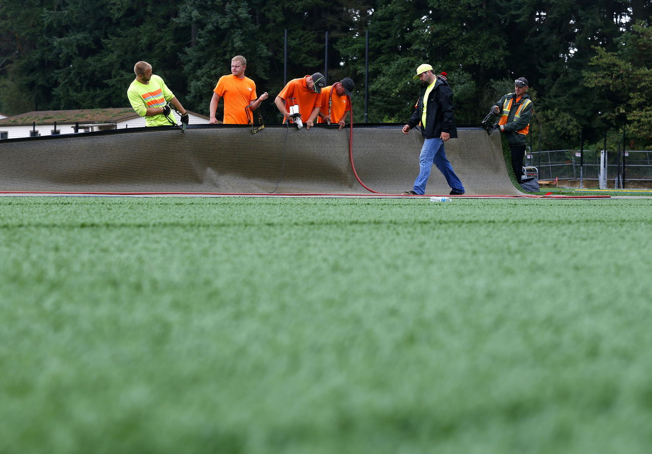 Contractors install turf on the fields at the old Woodway High School.