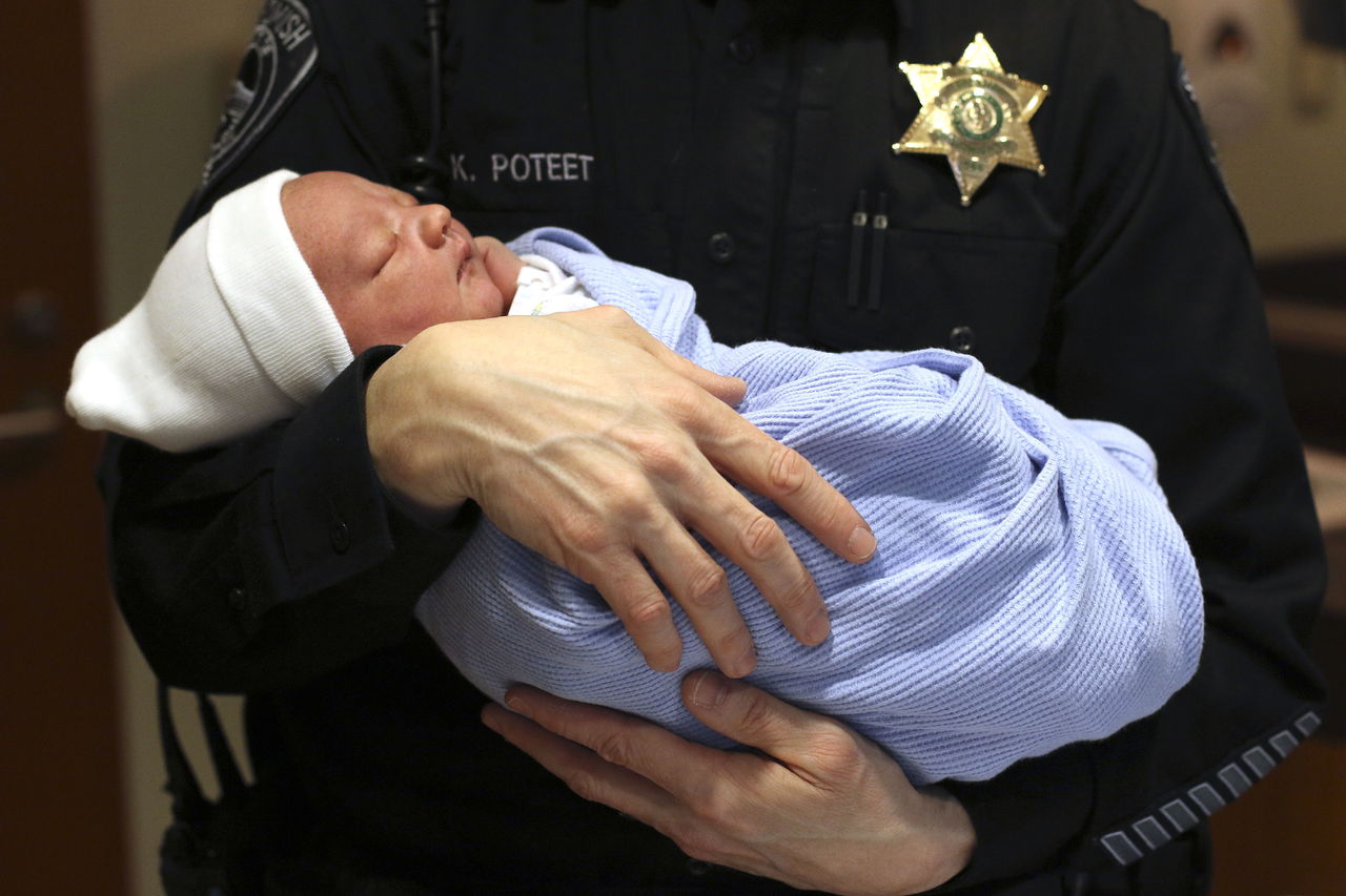 Snohomish Sheriff’s Deputy Keith Poteet holds a sleeping Case Daniel Bartelheimer at Providence Regional Medical Center Everett on Wednesday. Kyla Bartelheimer and her husband were heading to the hospital when she begin delivering the baby. Poteet arrived to help the delivery while on patrol in Snohomish.